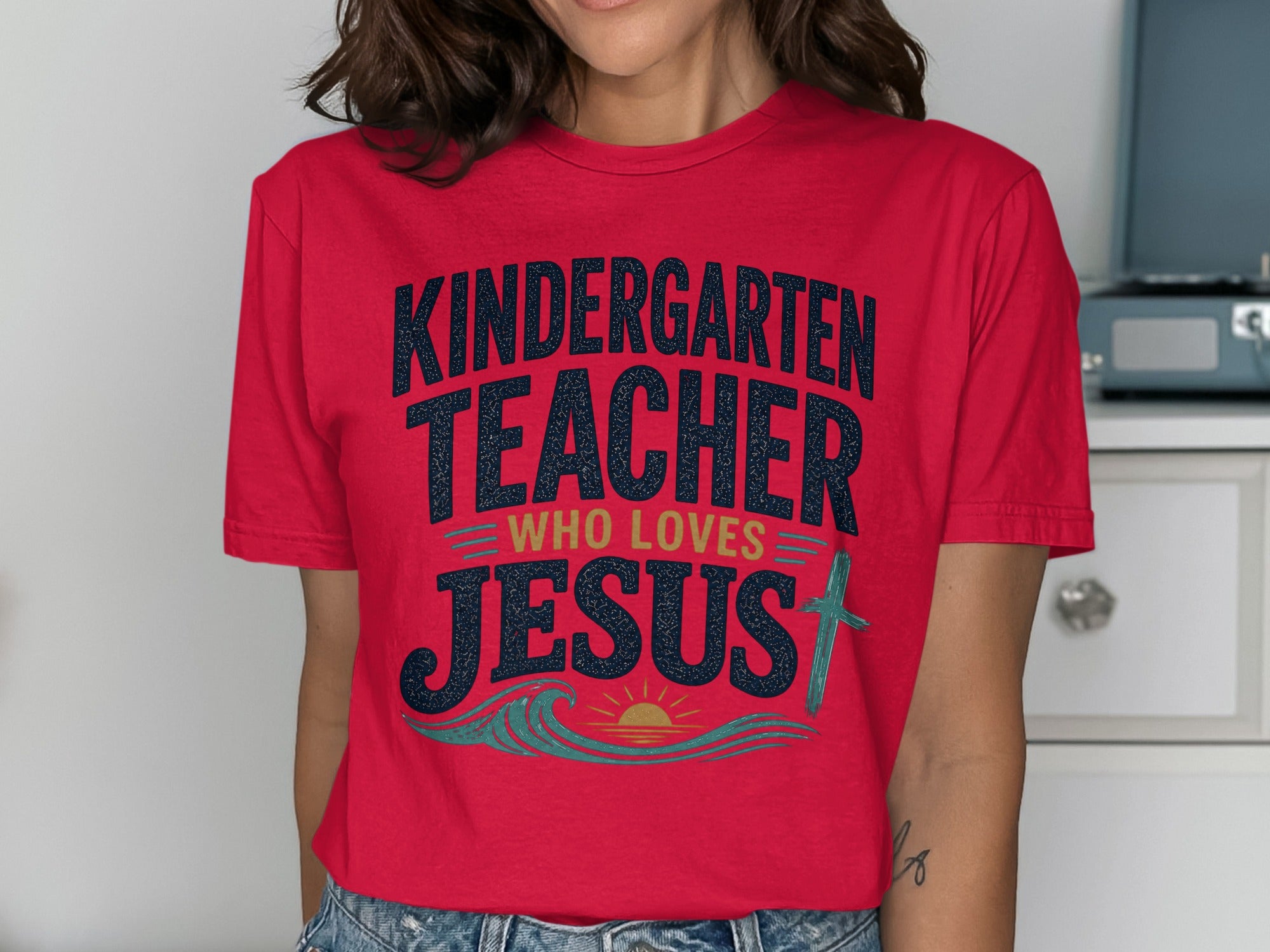 Red t-shirt with "Kindergarten Teacher Who Loves Jesus" text and a cross.