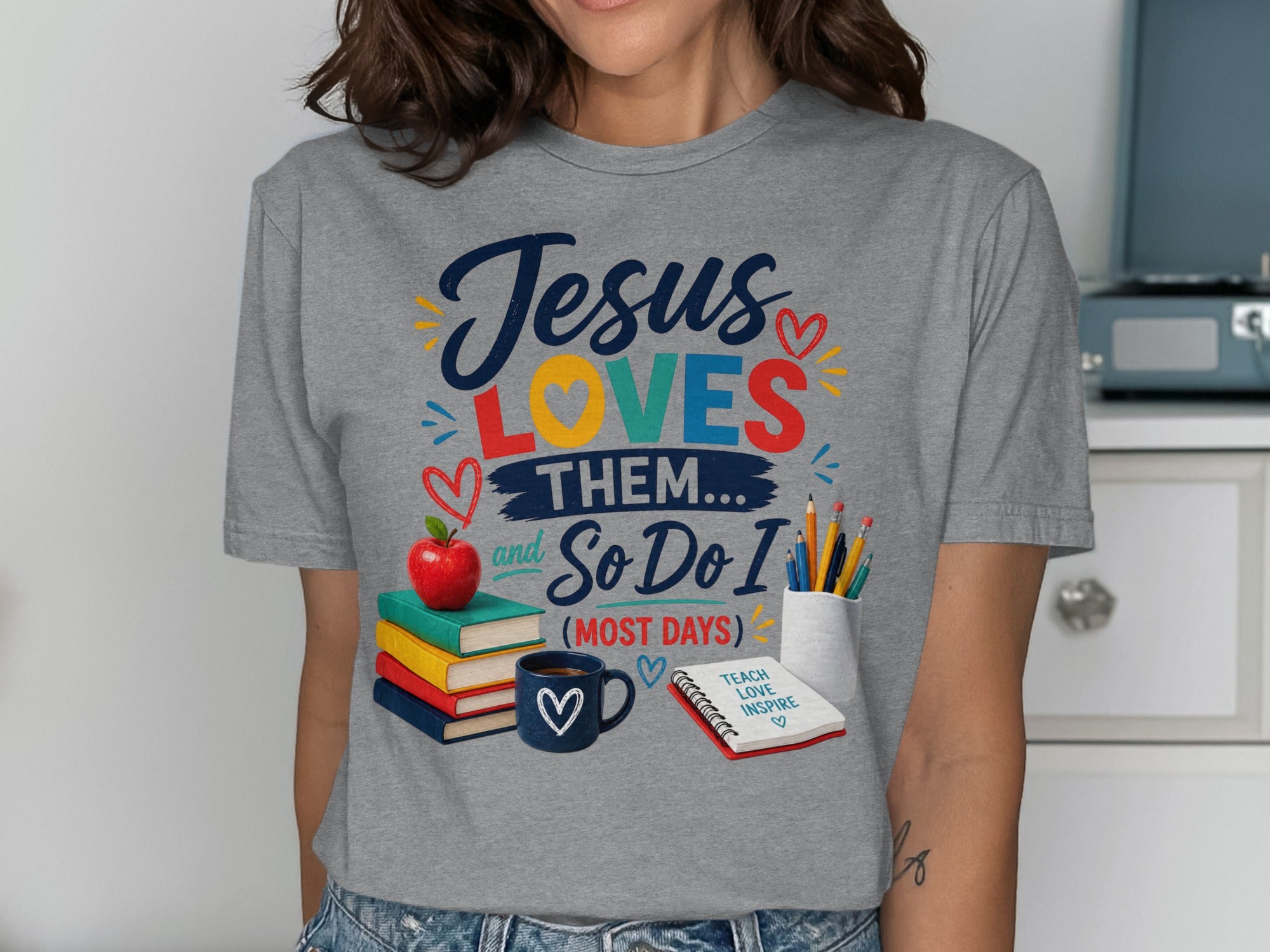 Grey t-shirt with "Jesus Loves Them... And So Do I (Most Days)" text.