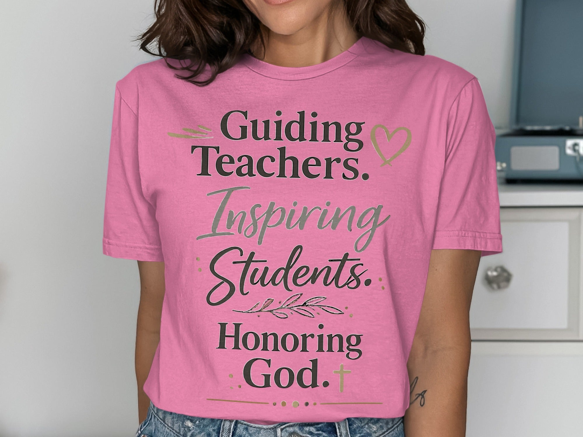 Pink t-shirt with text "Guiding Teachers. Inspiring Students. Honoring God."