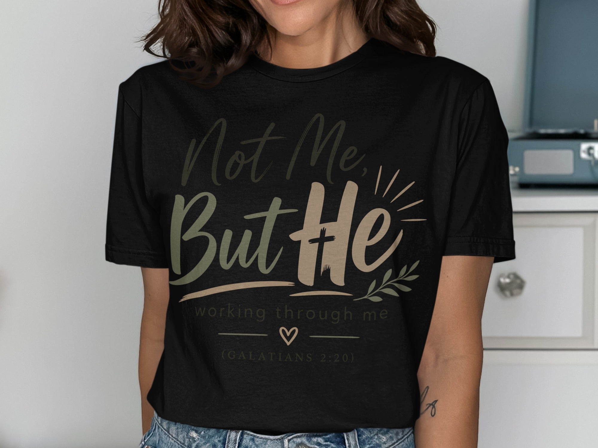 Black t-shirt with "Not Me, But He" text and Galatians 2:20 verse.