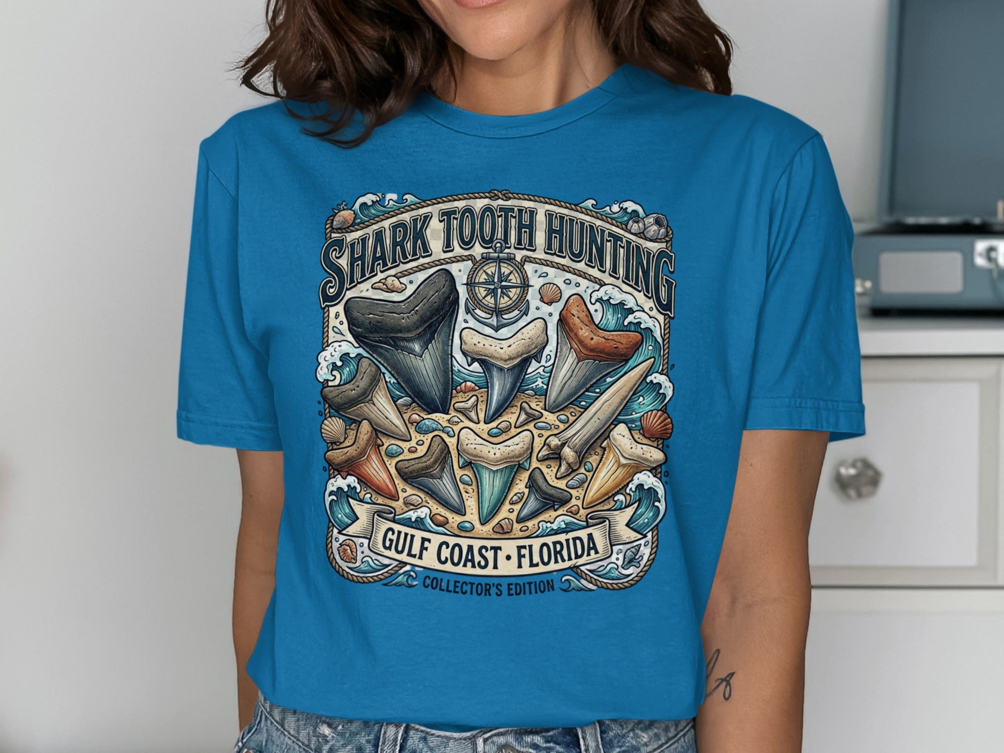 Shark tooth hunting design on a blue t-shirt reads "Gulf Coast Florida Collector's Edition".