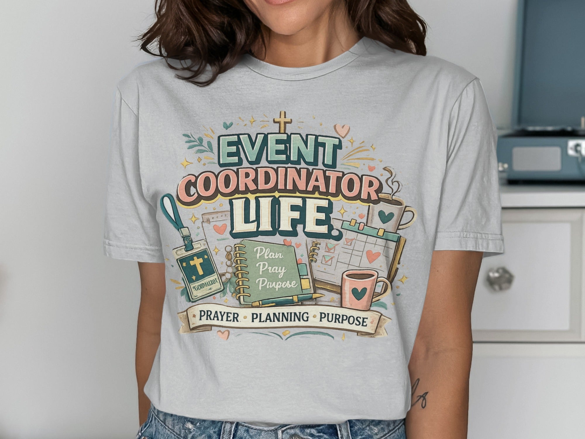 T-shirt with "Event Coordinator Life" text, planner, coffee, and icons.