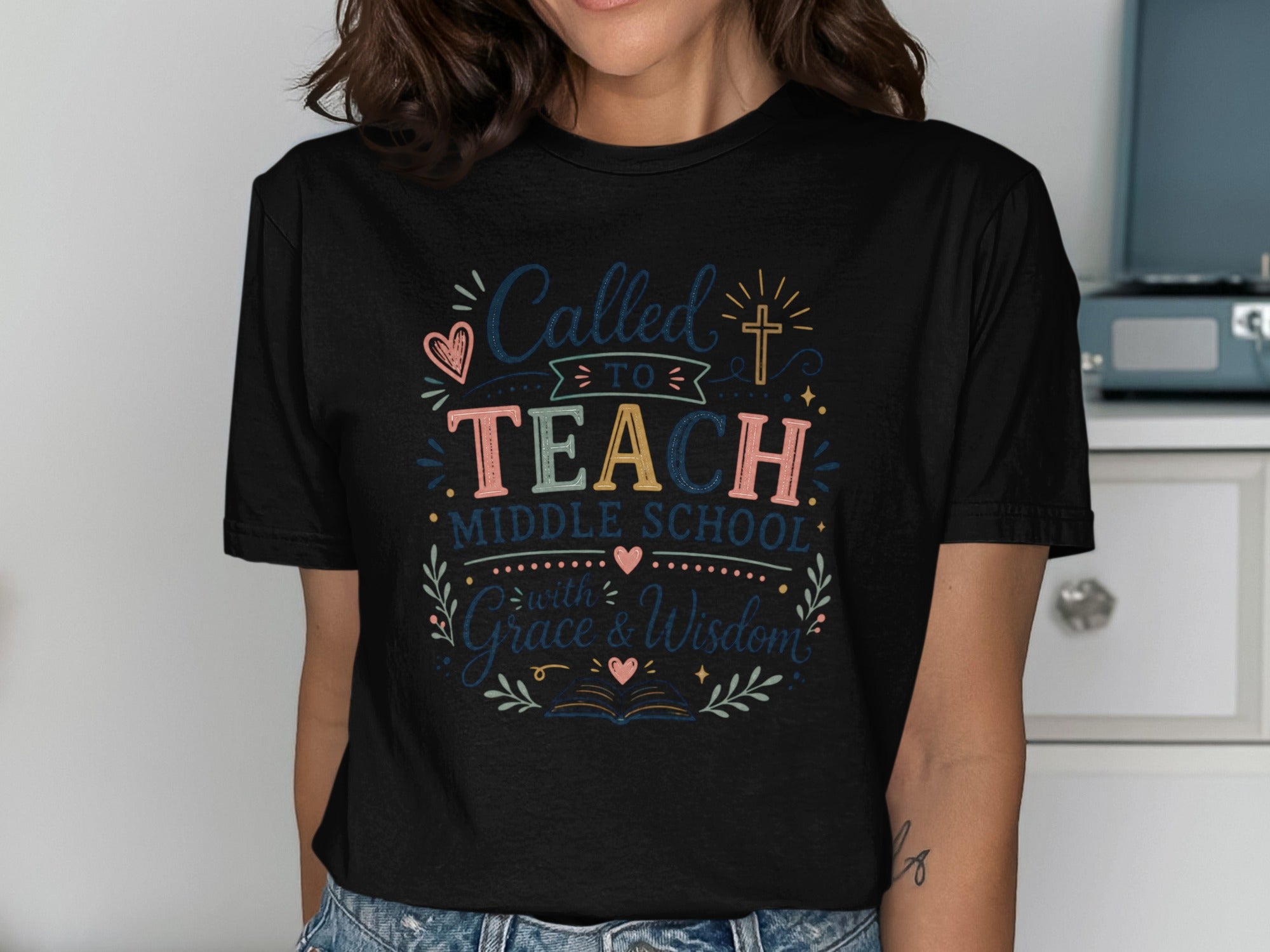 T-shirt with text "Called to Teach Middle School with Grace & Wisdom" and decorative elements.