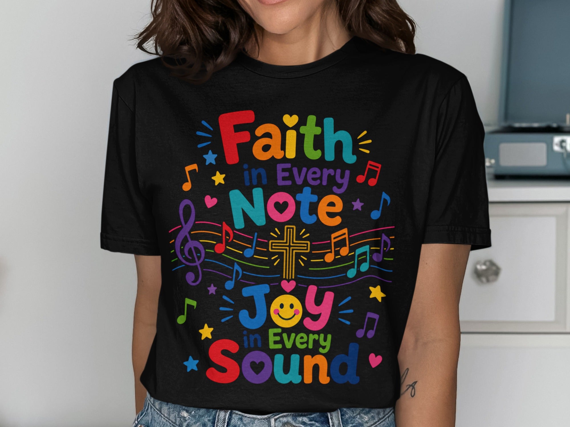 Black t-shirt with colorful text and musical notes, reading "Faith in Every Note, Joy in Every Sound".