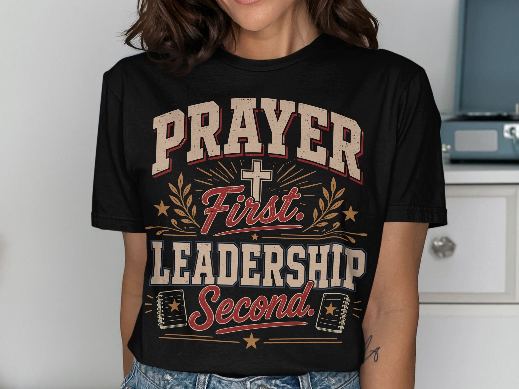 Black t-shirt with "Prayer First Leadership Second" text and cross graphic.