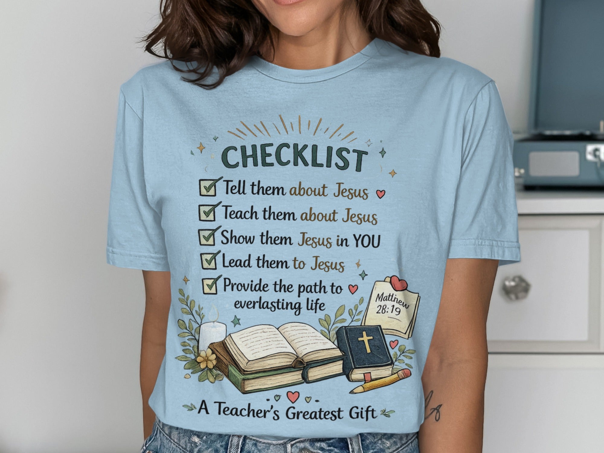 Light blue t-shirt with checklist for teaching about Jesus and a Bible.