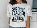 White t-shirt with text "2nd Grade Teacher Who Loves Jesus" and a cross.