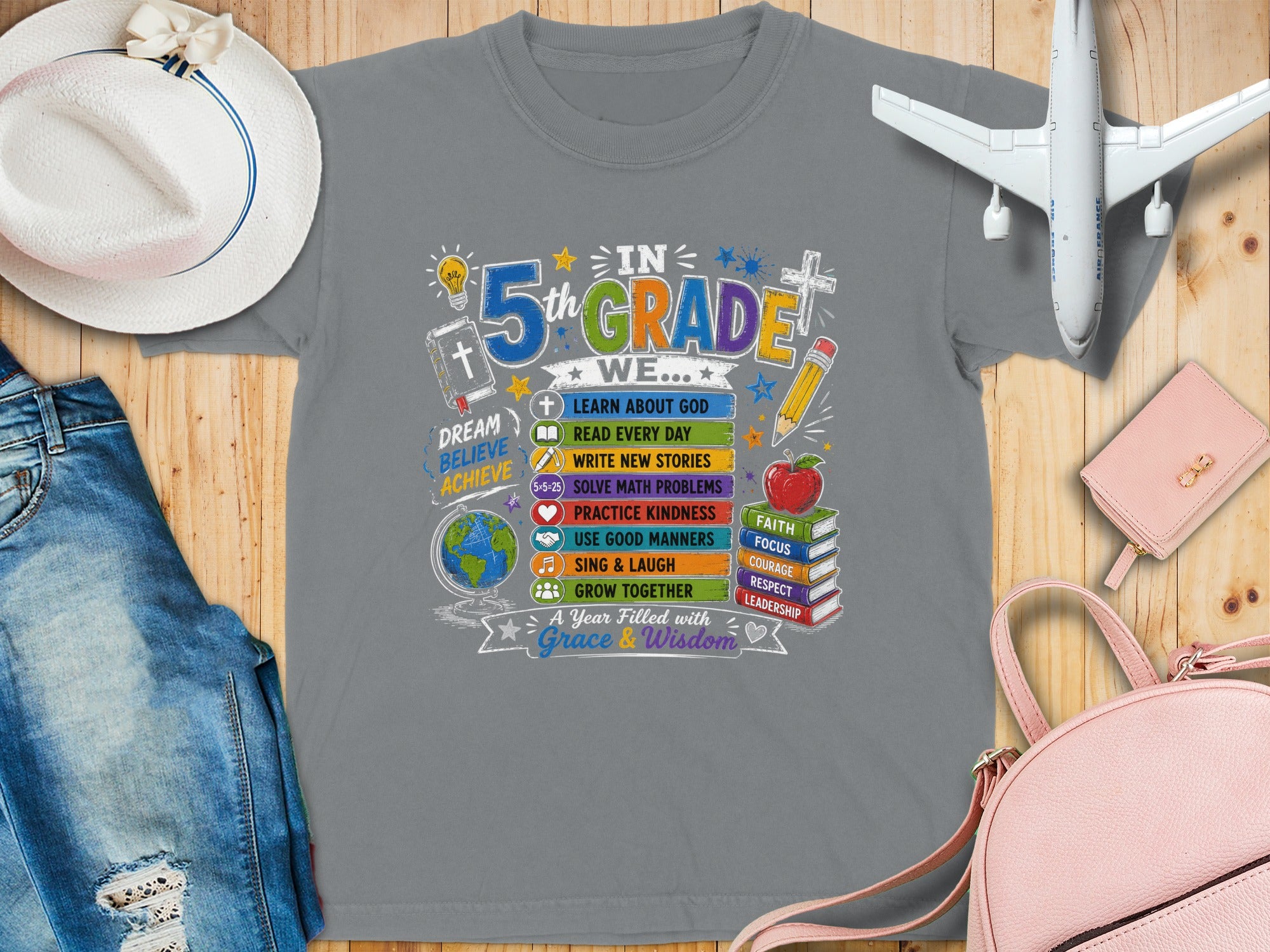 T-shirt with "5th Grade" design featuring school-related icons and positive phrases.