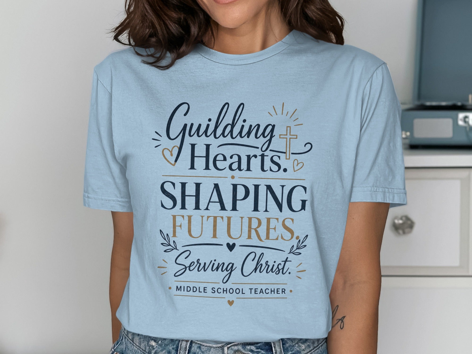 Light blue t-shirt with "Guiding Hearts, Shaping Futures, Serving Christ. Middle School Teacher." text.