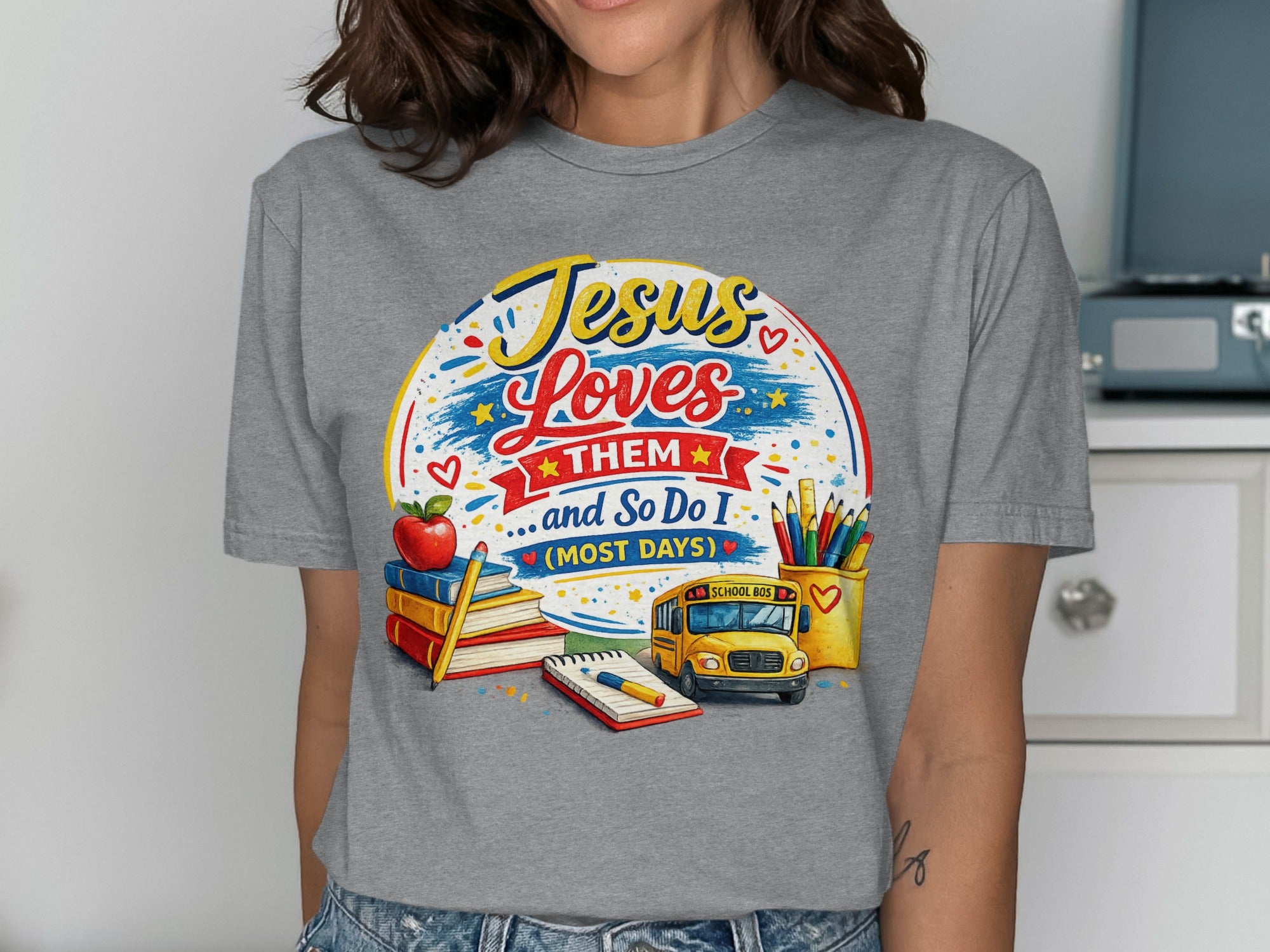 T-shirt with "Jesus Loves Them... and So Do I (Most Days)" and school-themed graphics.