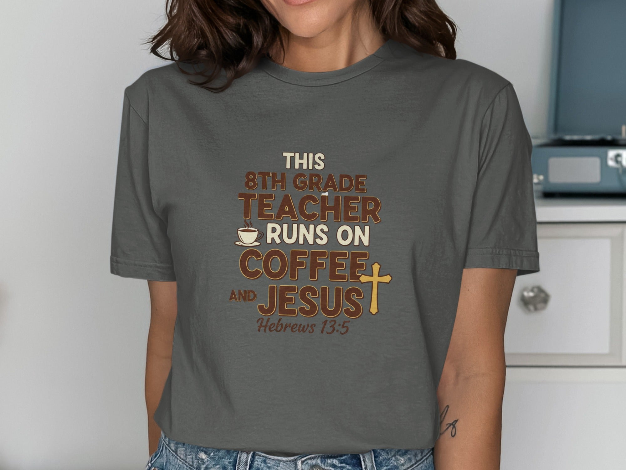 Dark grey t-shirt with text: "This 8th grade teacher runs on coffee and Jesus. Hebrews 13:5."