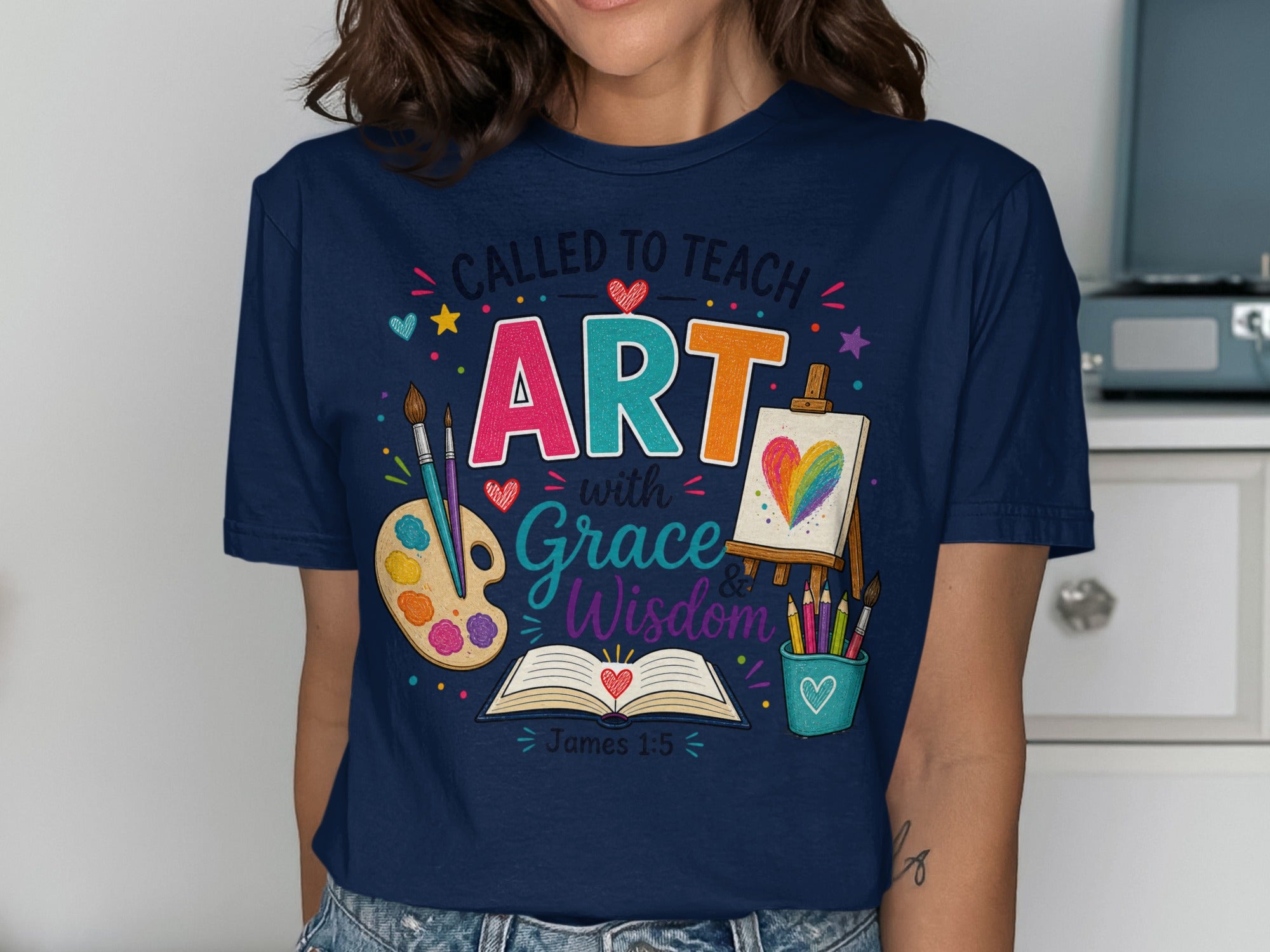 T-shirt with "Called to Teach Art with Grace & Wisdom" and art supplies.