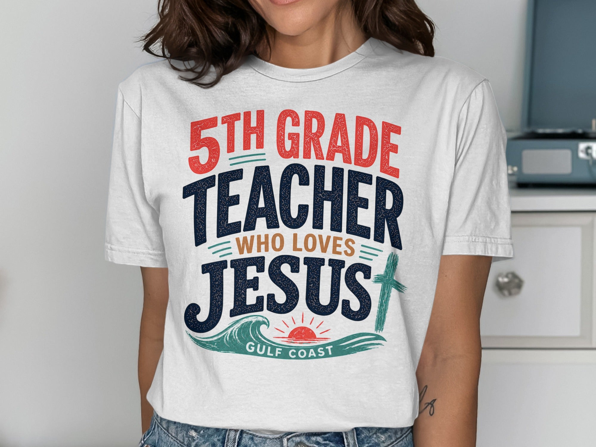5th Grade Teacher Who Loves Jesus graphic t-shirt with cross and waves.