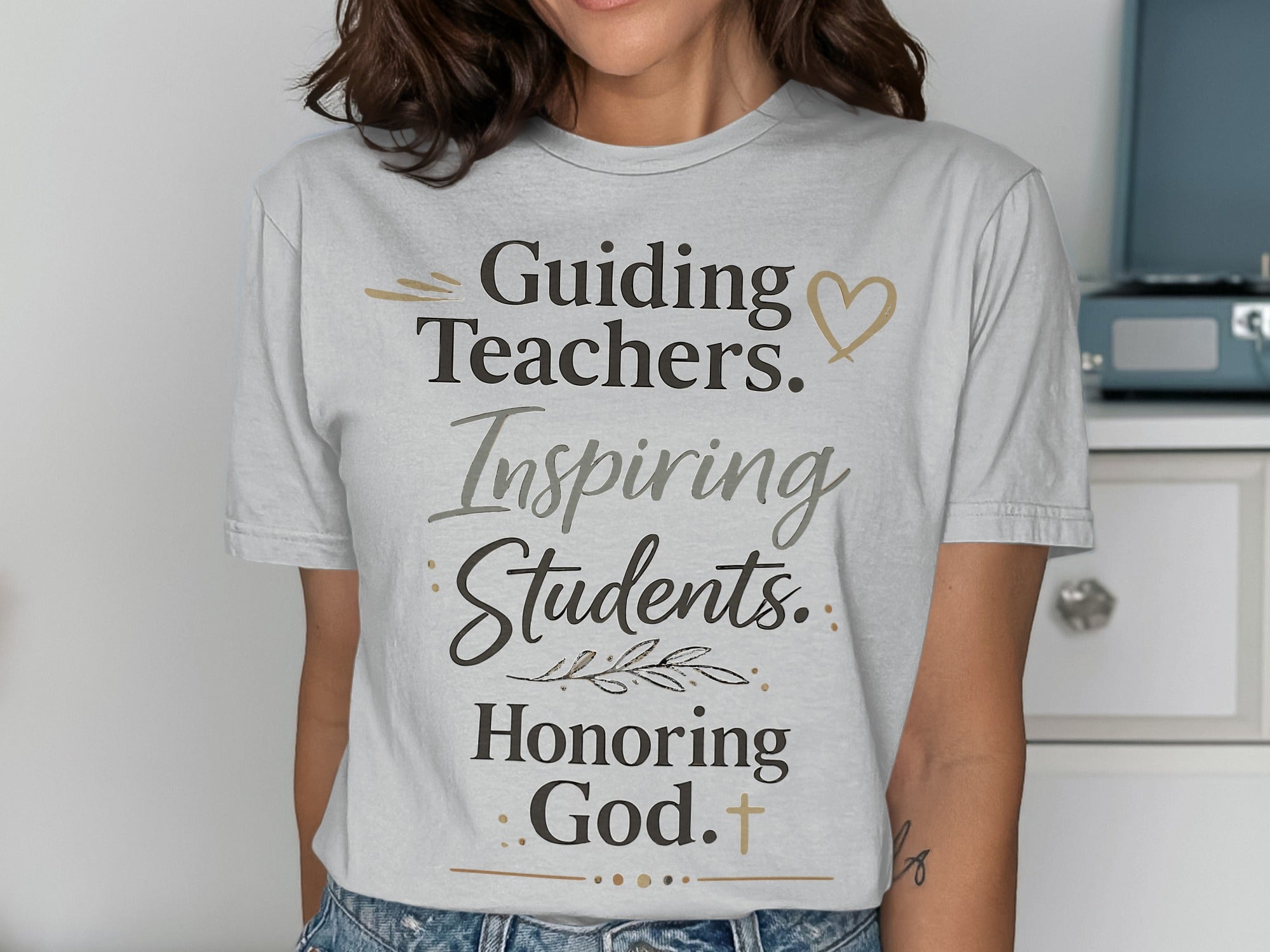 T-shirt with "Guiding Teachers. Inspiring Students. Honoring God." text and decorative elements.