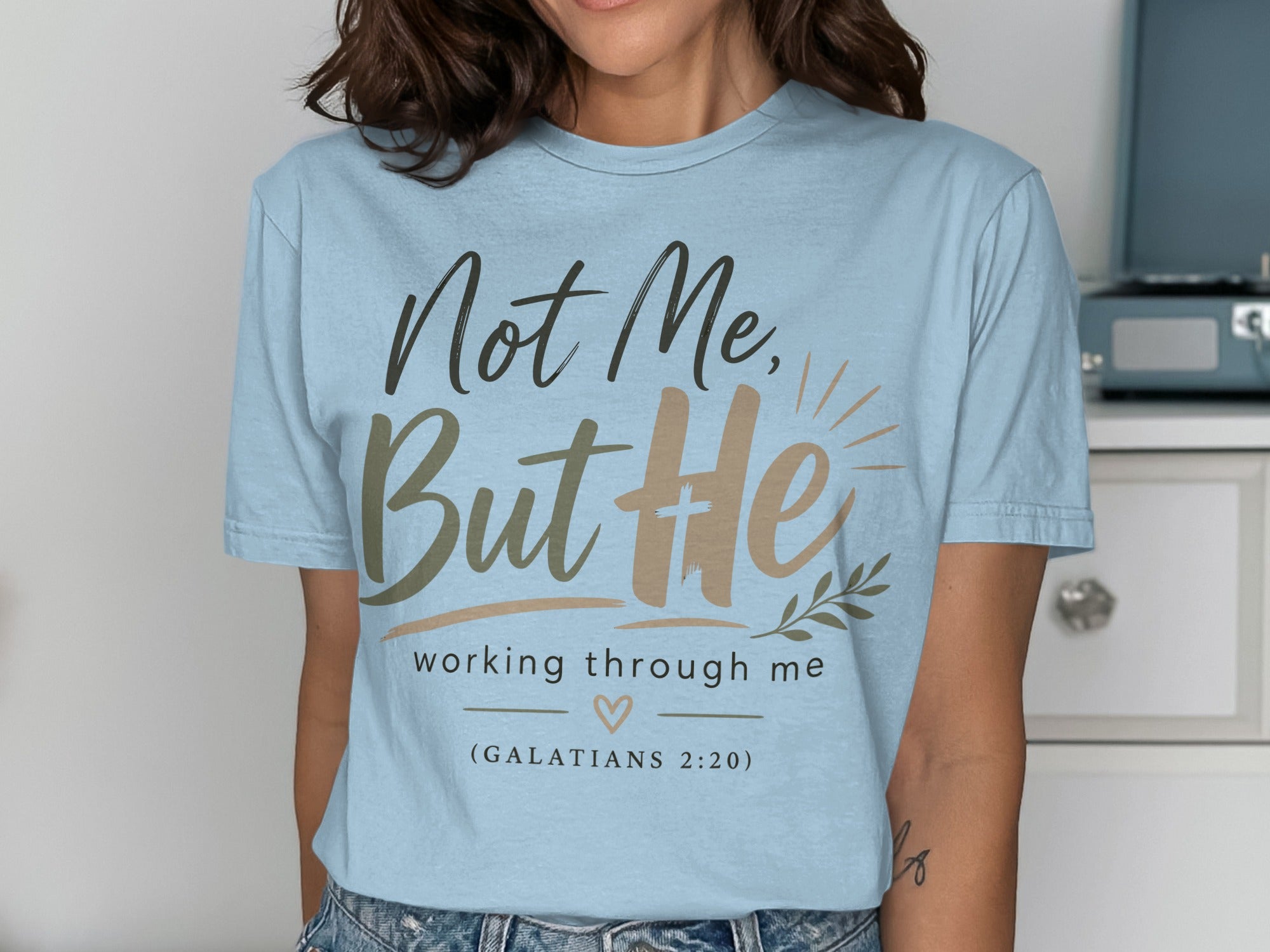 Light blue t-shirt with "Not Me, But He" and Bible verse.