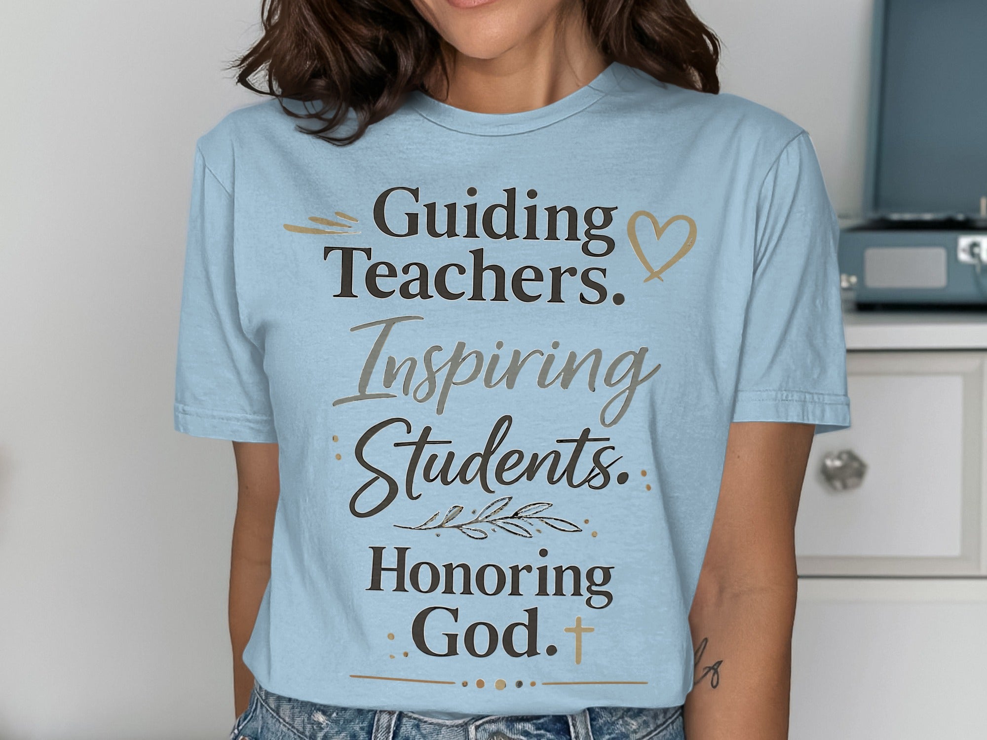 Light blue t-shirt with "Guiding Teachers. Inspiring Students. Honoring God." text.