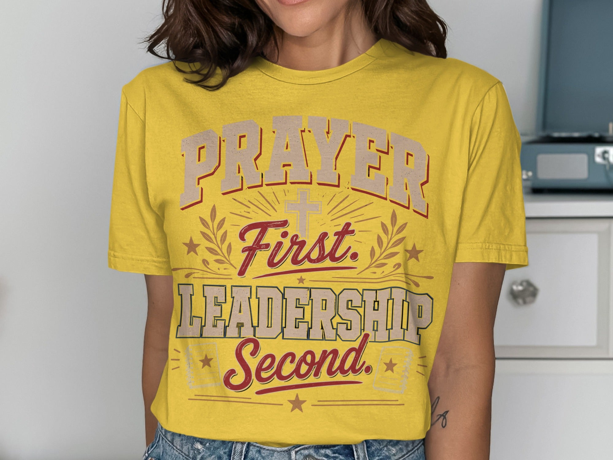 Yellow t-shirt with "Prayer First. Leadership Second." text and a cross graphic.