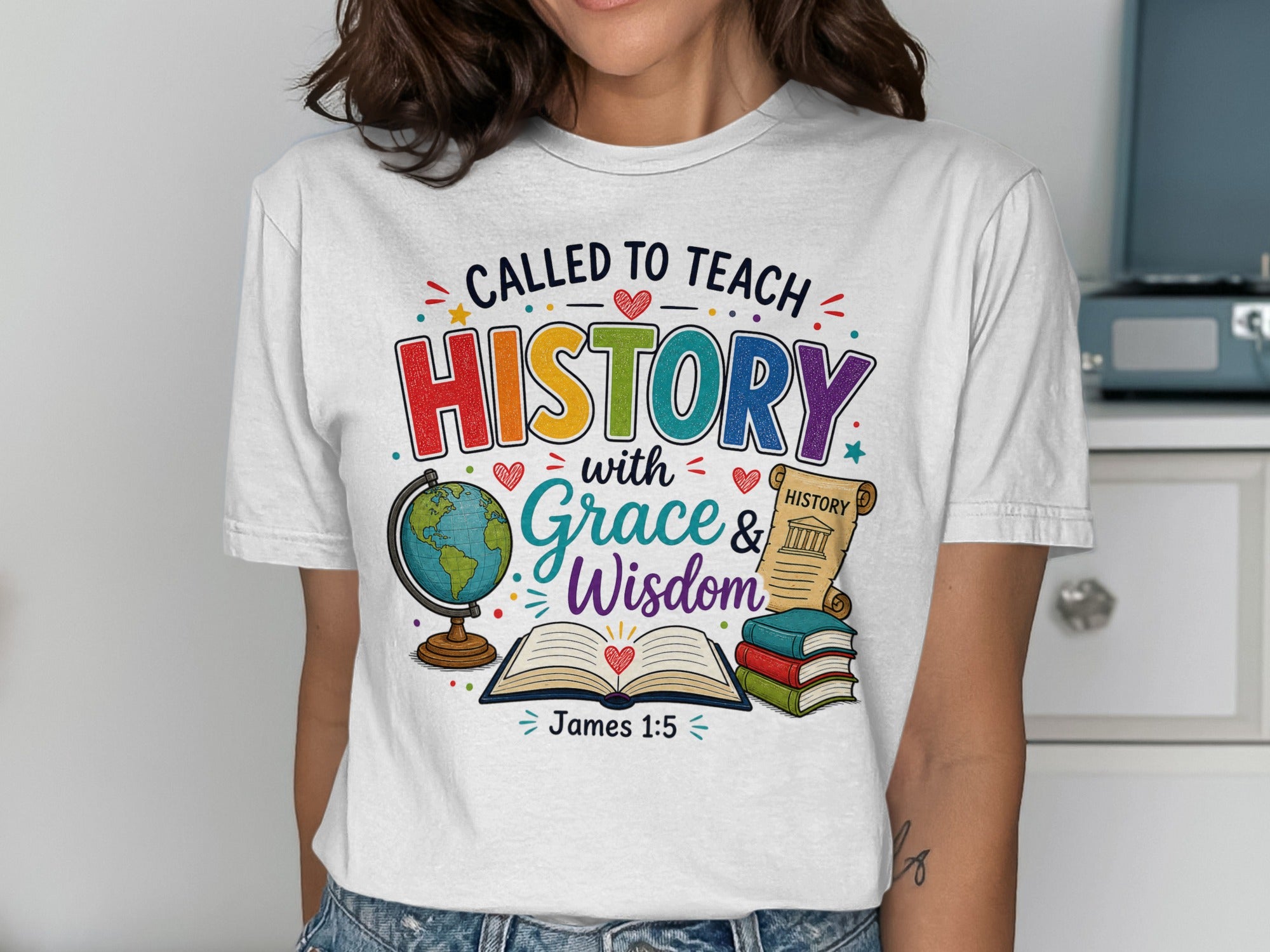 White t-shirt with colorful text "Called to Teach History with Grace & Wisdom" and book, globe, scroll.