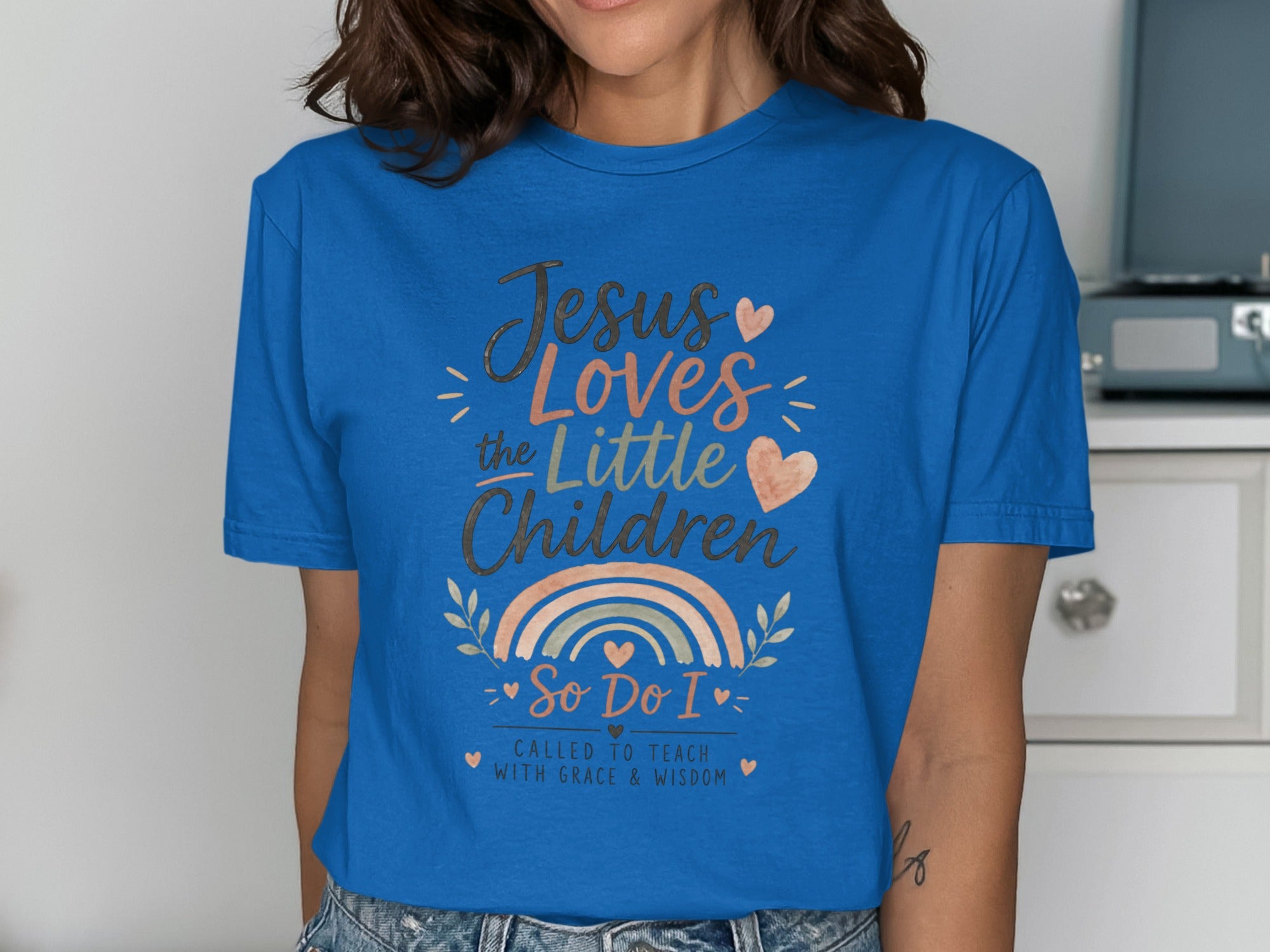 Blue t-shirt with "Jesus Loves the Little Children" text and rainbow graphic.