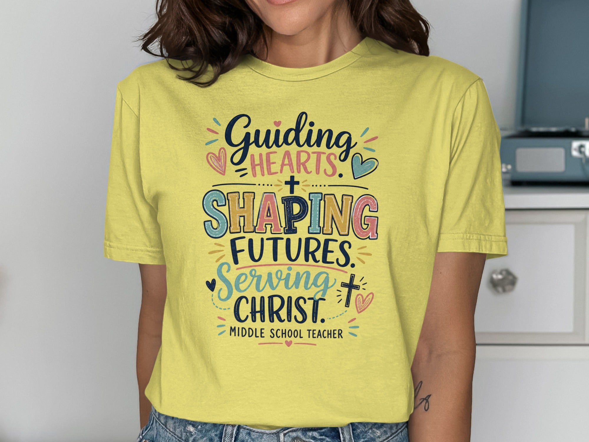 Yellow t-shirt with "Guiding Hearts, Shaping Futures, Serving Christ" text.