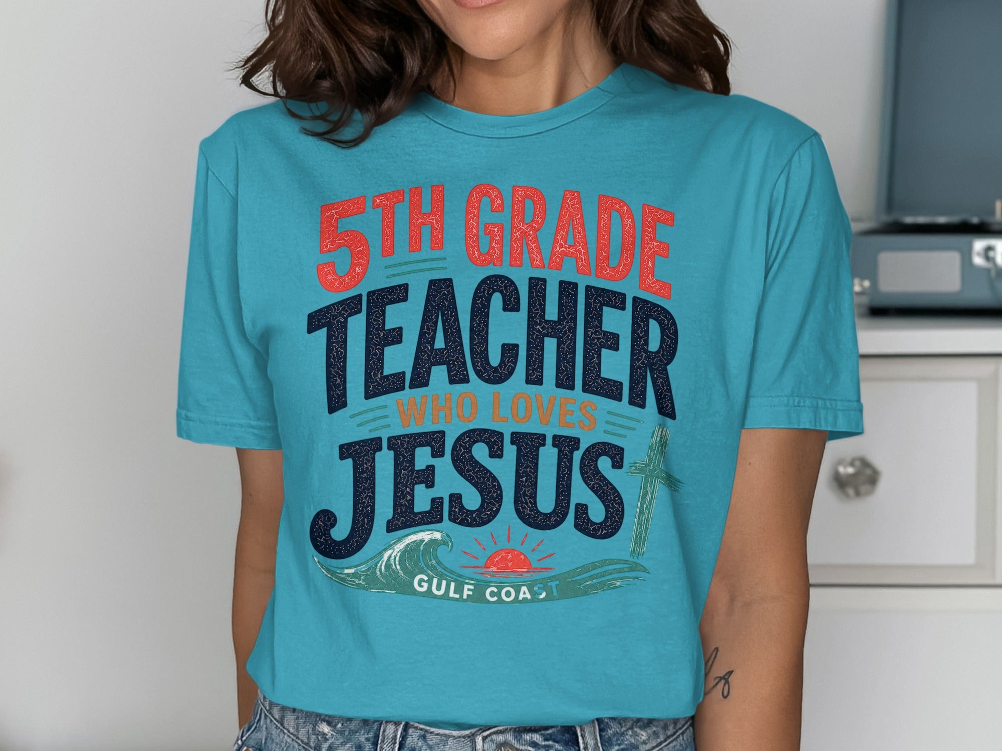 Blue t-shirt with "5th Grade Teacher Who Loves Jesus" and a cross graphic.