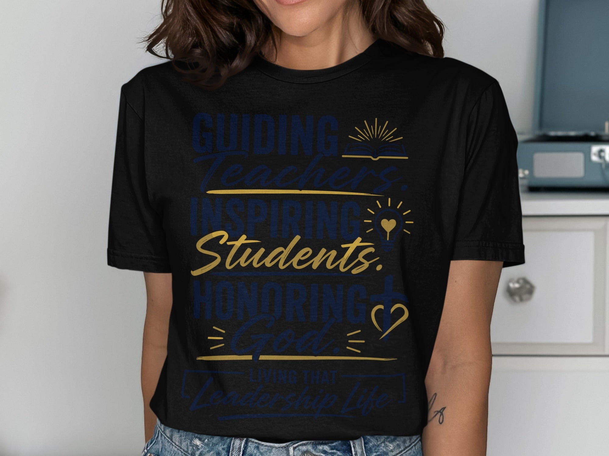 Black t-shirt with "Guiding Teachers, Inspiring Students, Honoring God, Living That Leadership Life" text.