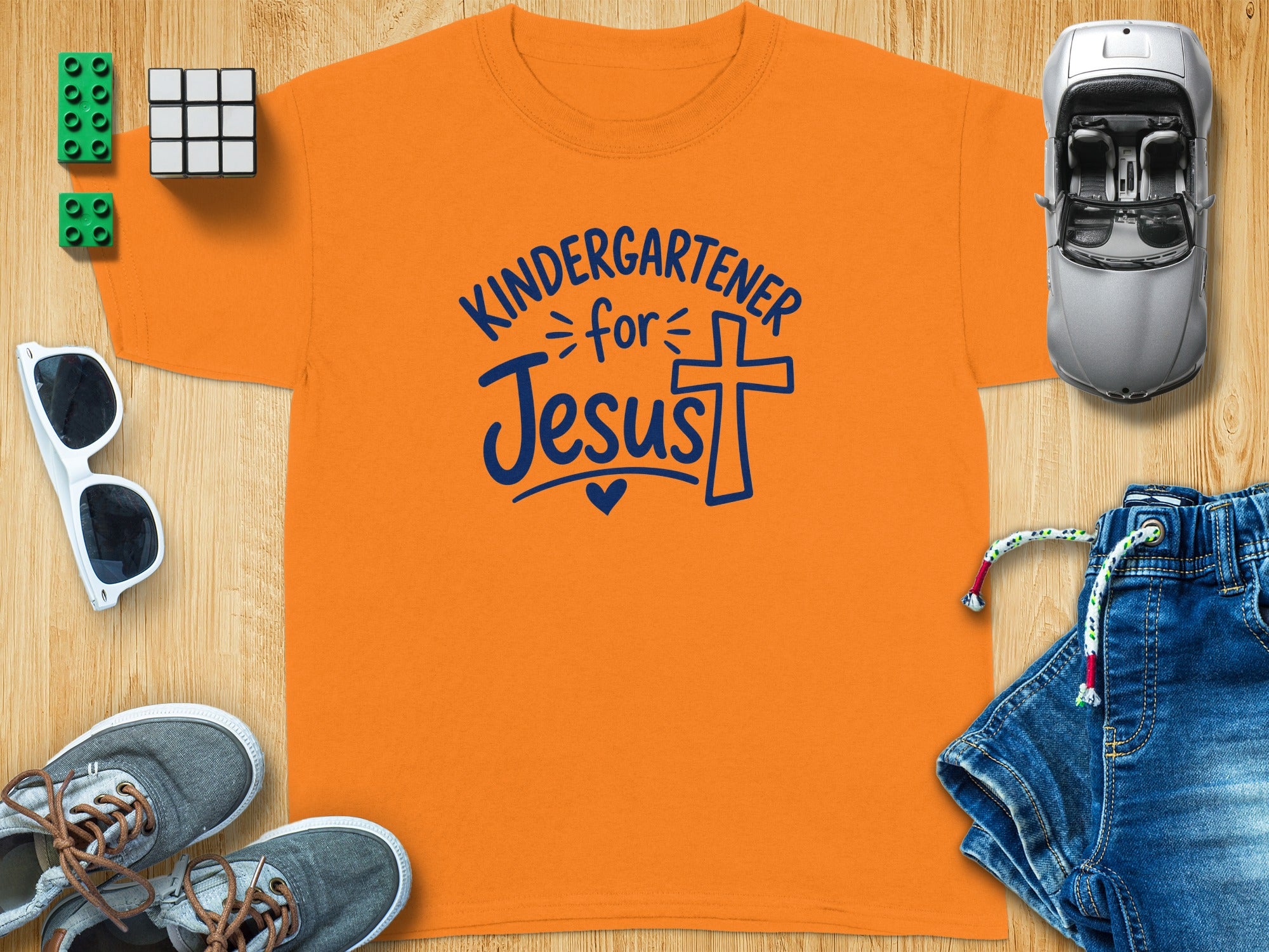 Orange t-shirt with "Kindergartener for Jesus" text and a cross.