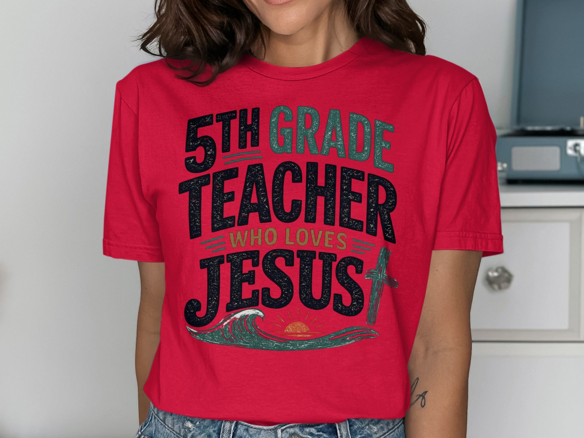 Red t-shirt with "5th Grade Teacher Who Loves Jesus" text and wave graphic.