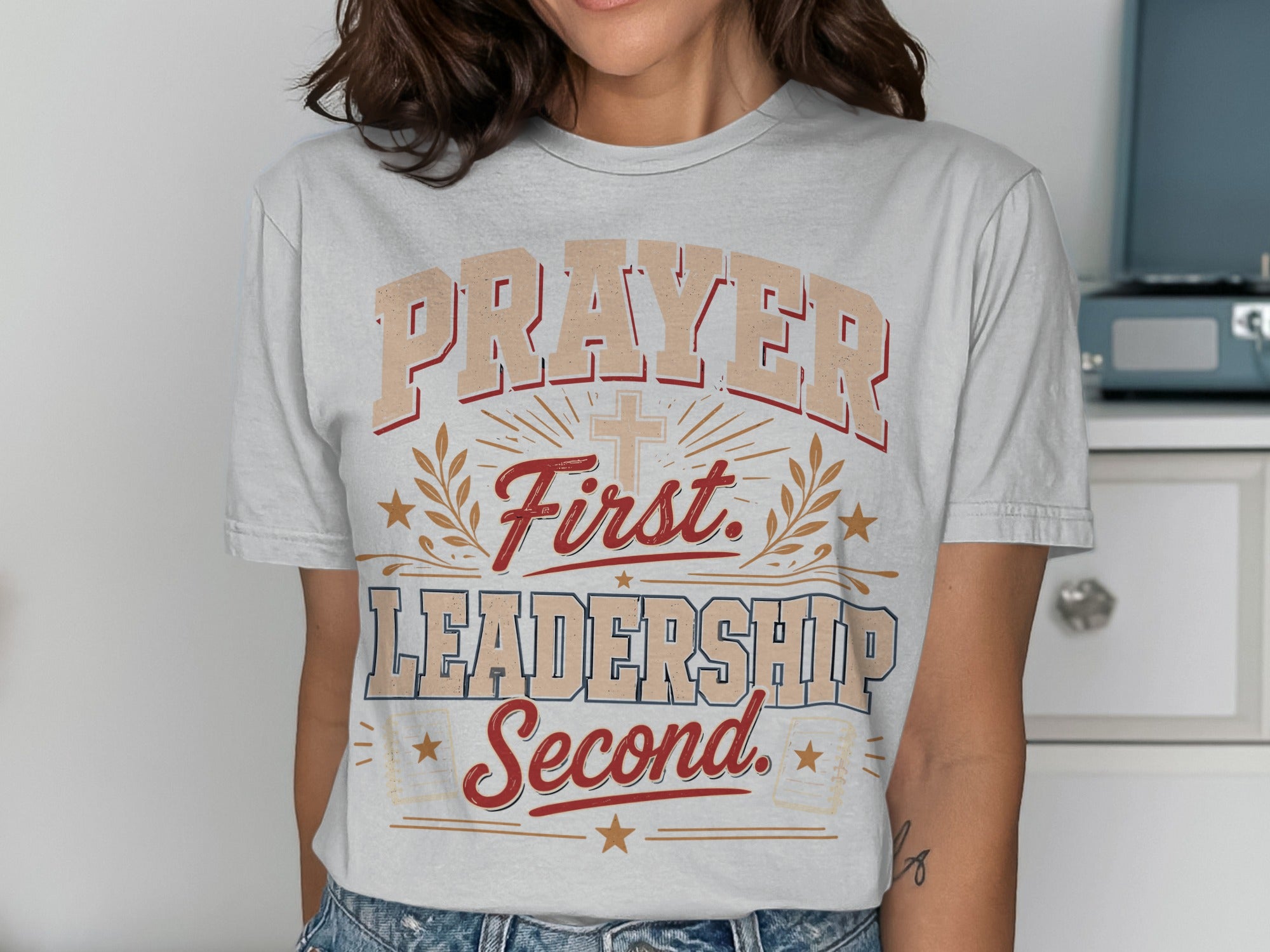 White t-shirt with "Prayer First. Leadership Second." text and cross graphic.