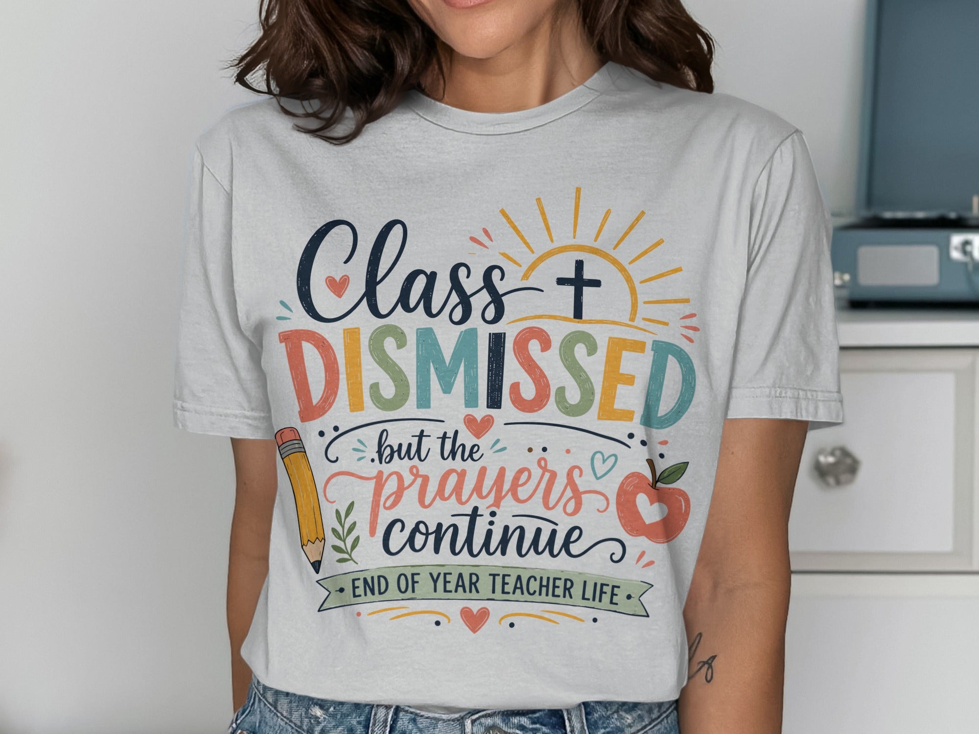 Class Dismissed but the prayers continue text on a t-shirt with graphics.