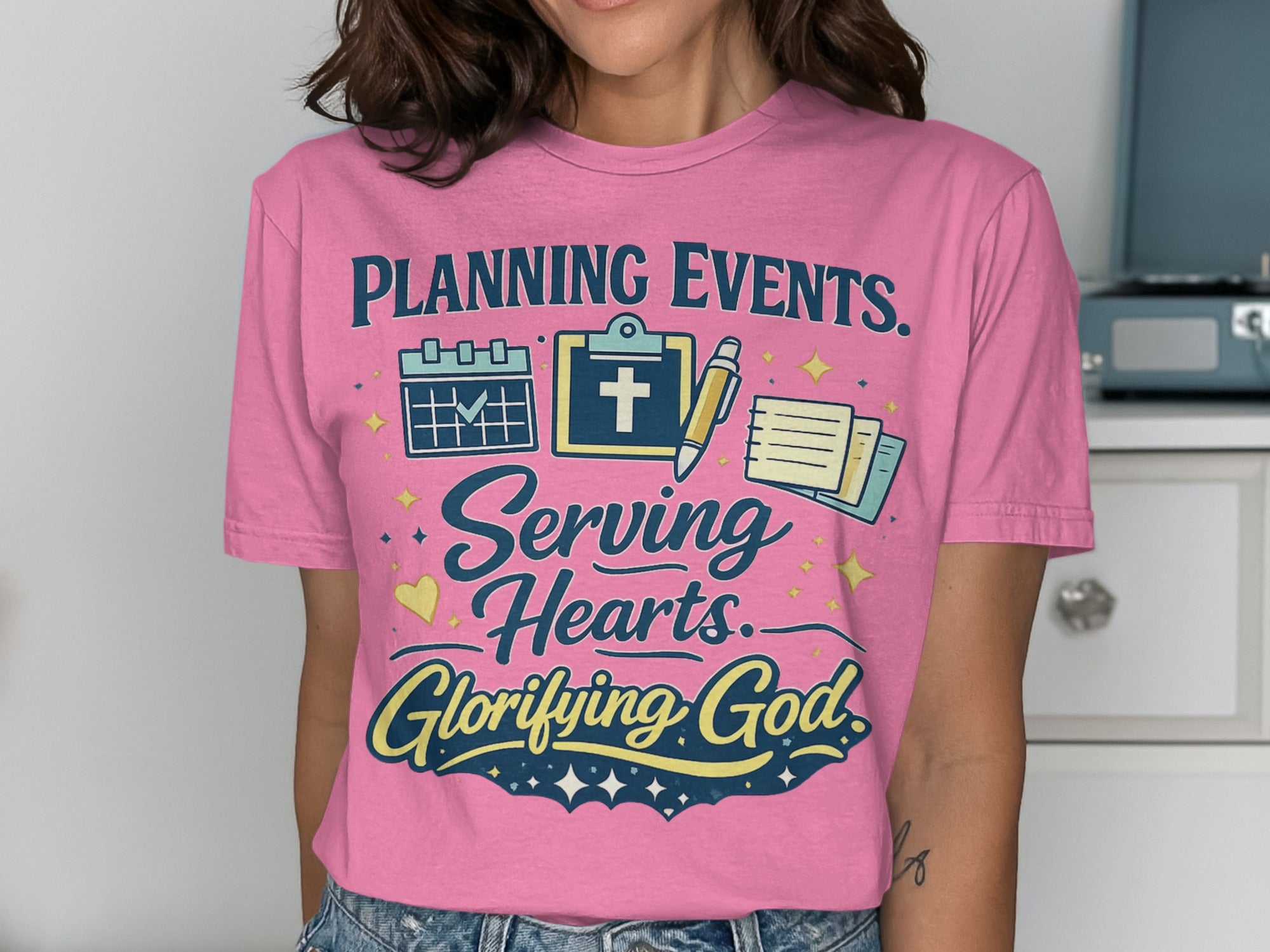 Pink t-shirt with text "Planning Events. Serving Hearts. Glorifying God."