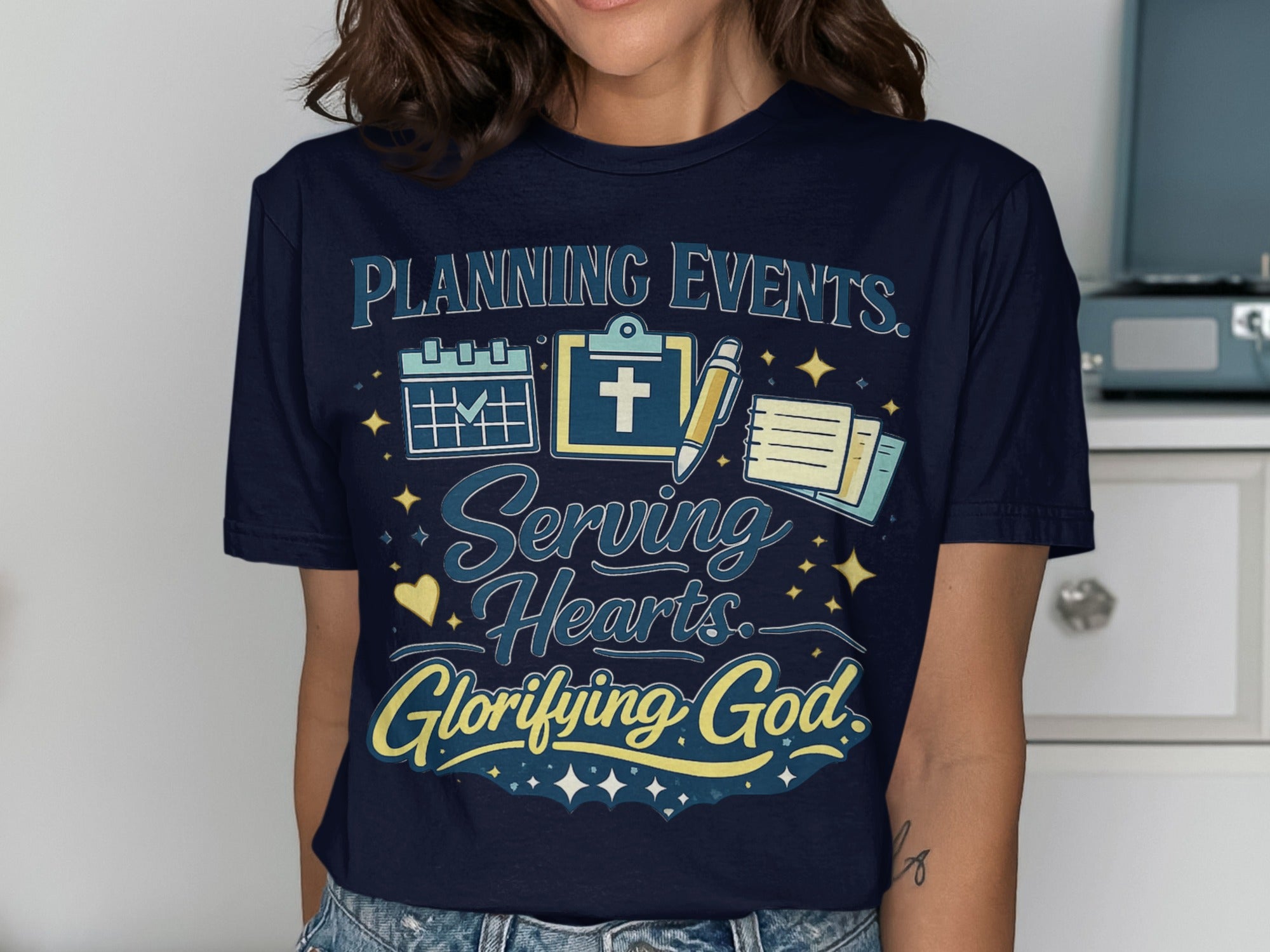 Dark blue t-shirt with "PLANNING EVENTS. Serving Hearts. Glorifying God." text.