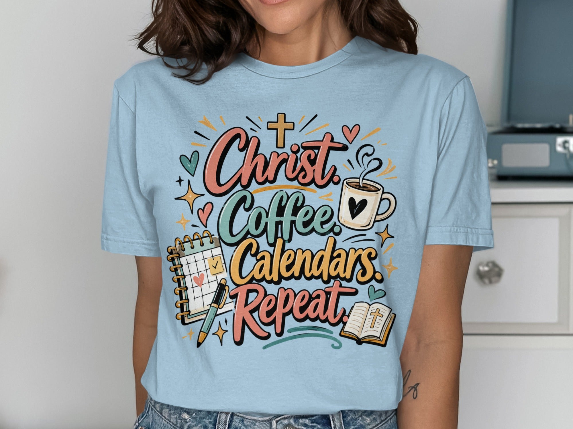 Light blue t-shirt with "Christ Coffee Calendars Repeat" text and graphics.