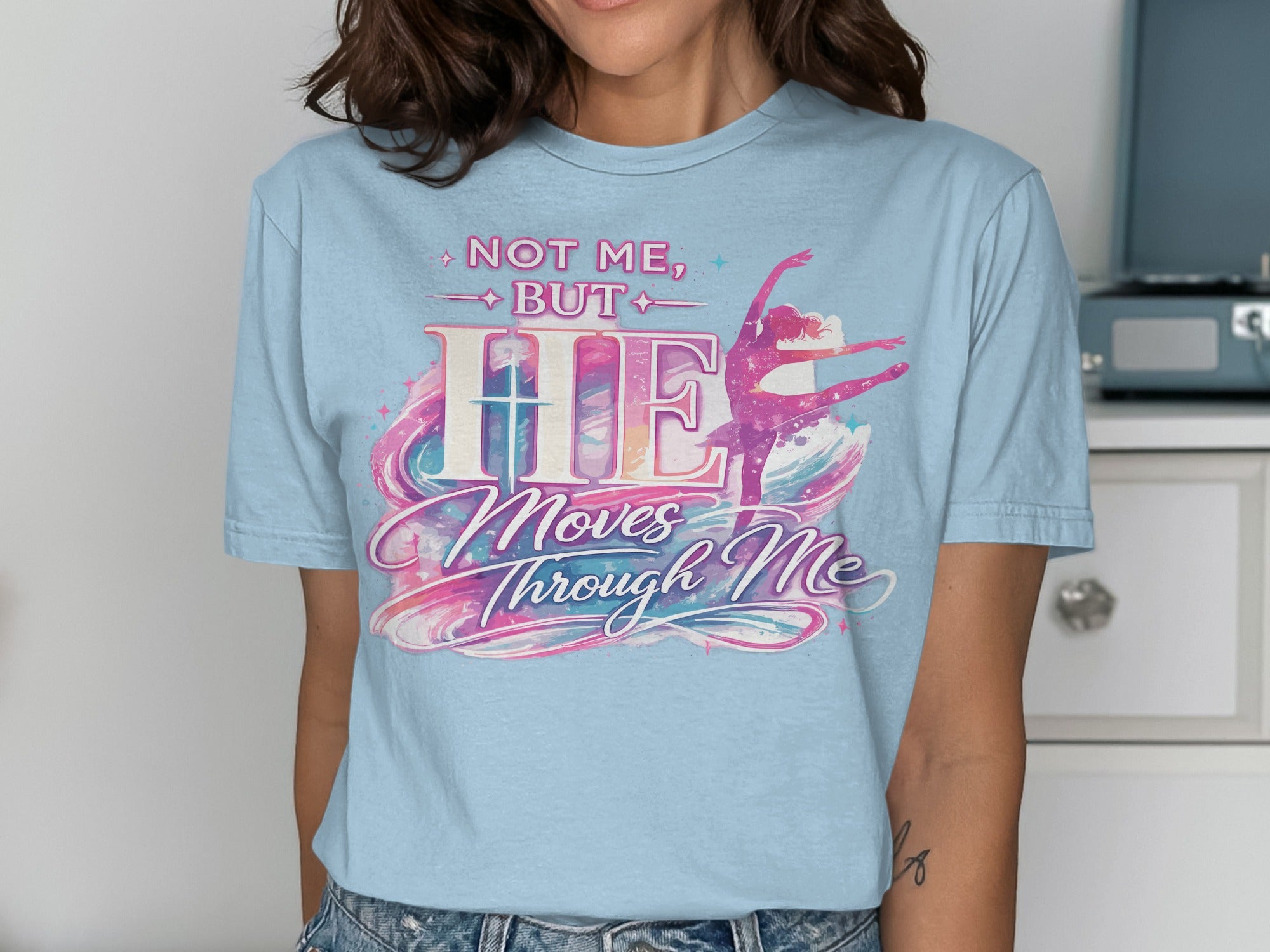 Light blue t-shirt with "Not Me, But HE Moves Through Me" and a ballerina.