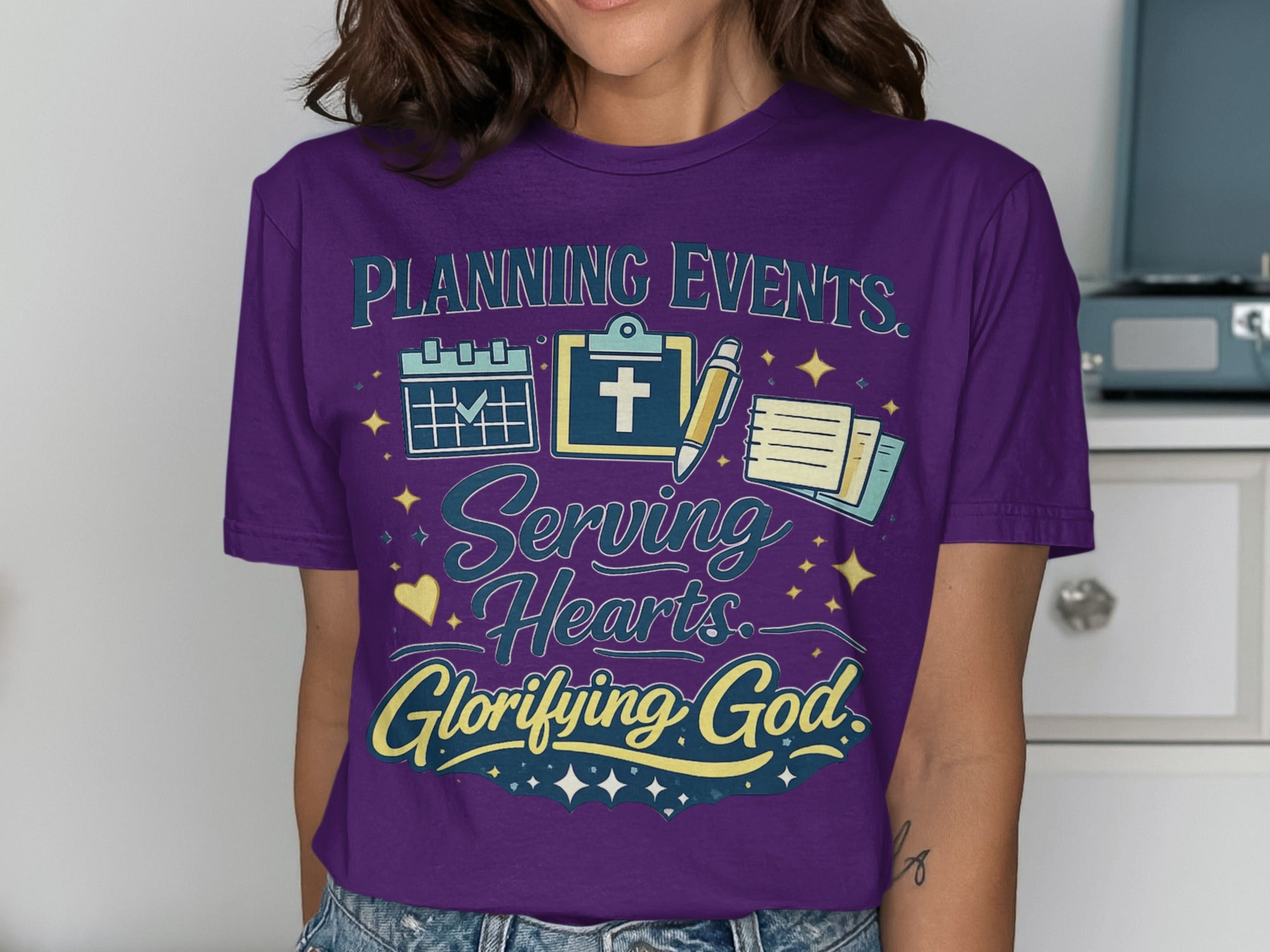 Purple t-shirt with "Planning Events. Serving Hearts. Glorifying God." text.
