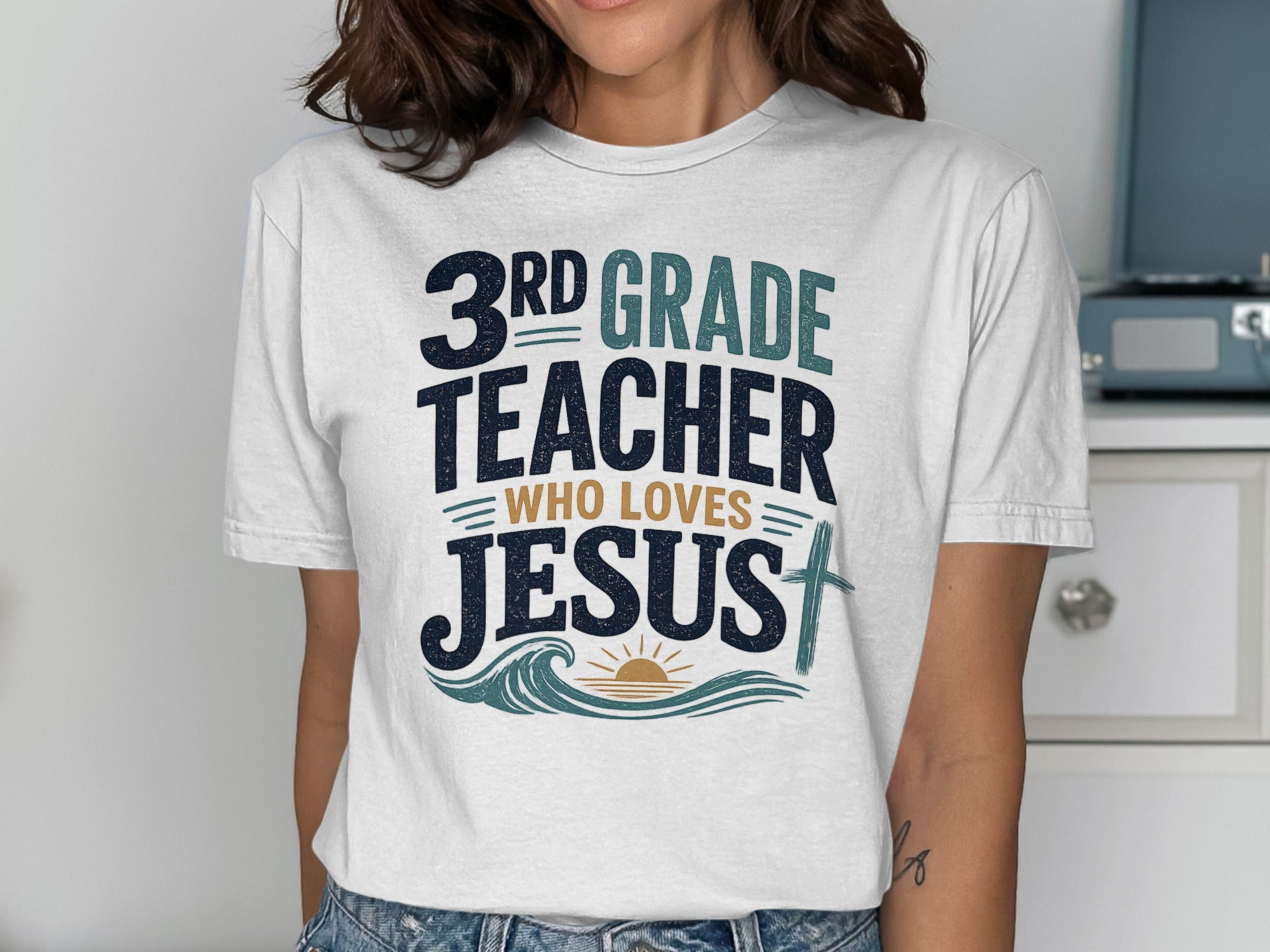 White t-shirt with "3rd grade teacher who loves Jesus" text and cross design.
