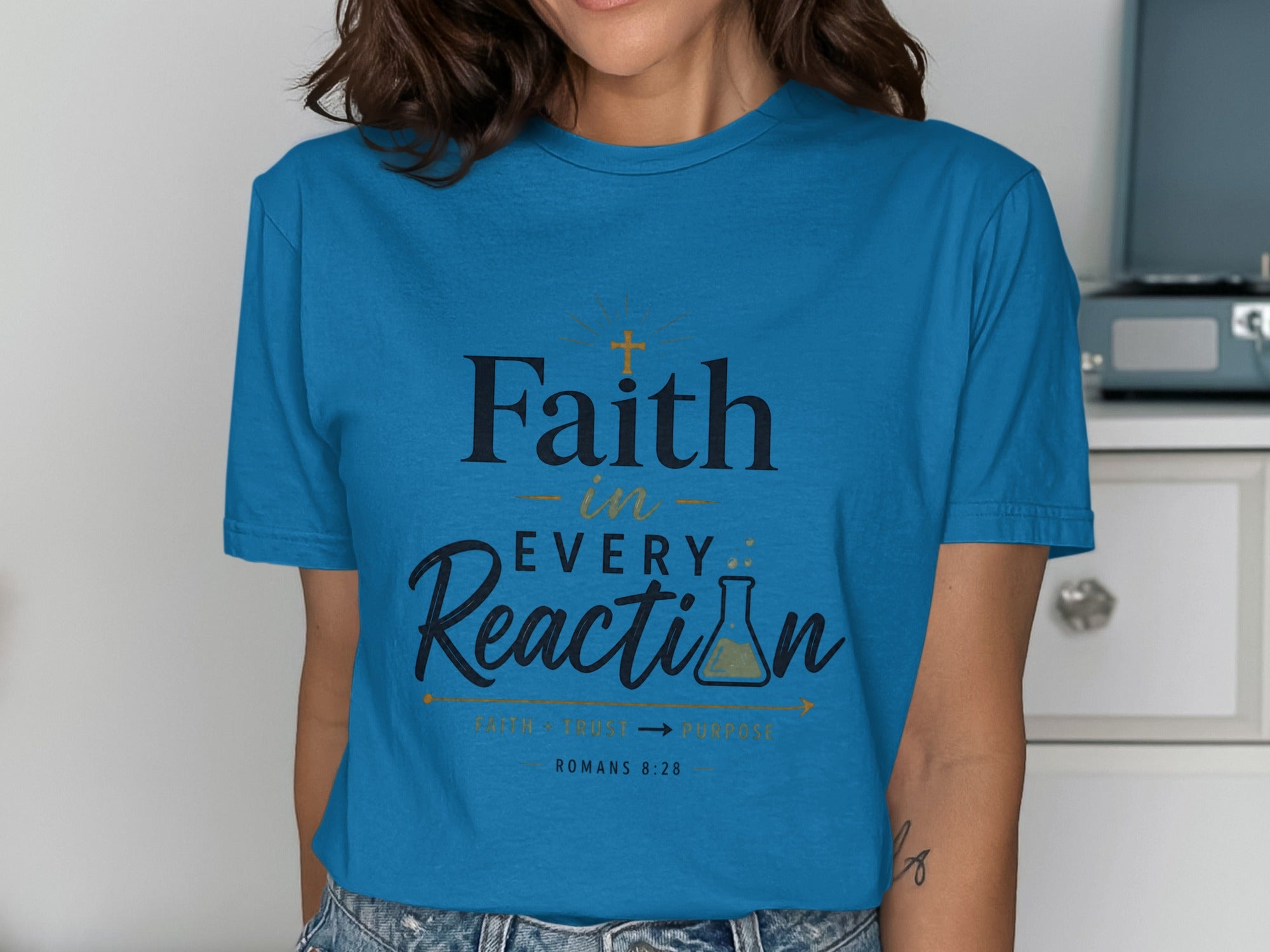 Blue t-shirt with "Faith in EVERY Reaction" and Romans 8:28 text.