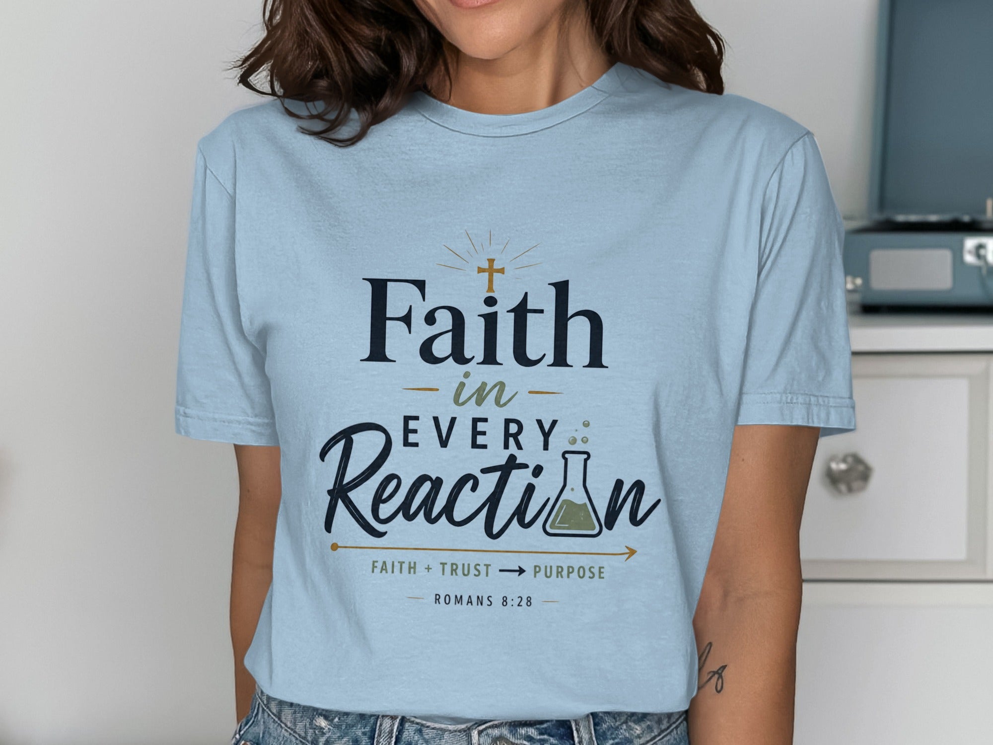 Light blue t-shirt with "Faith in Every Reaction" text and flask graphic.