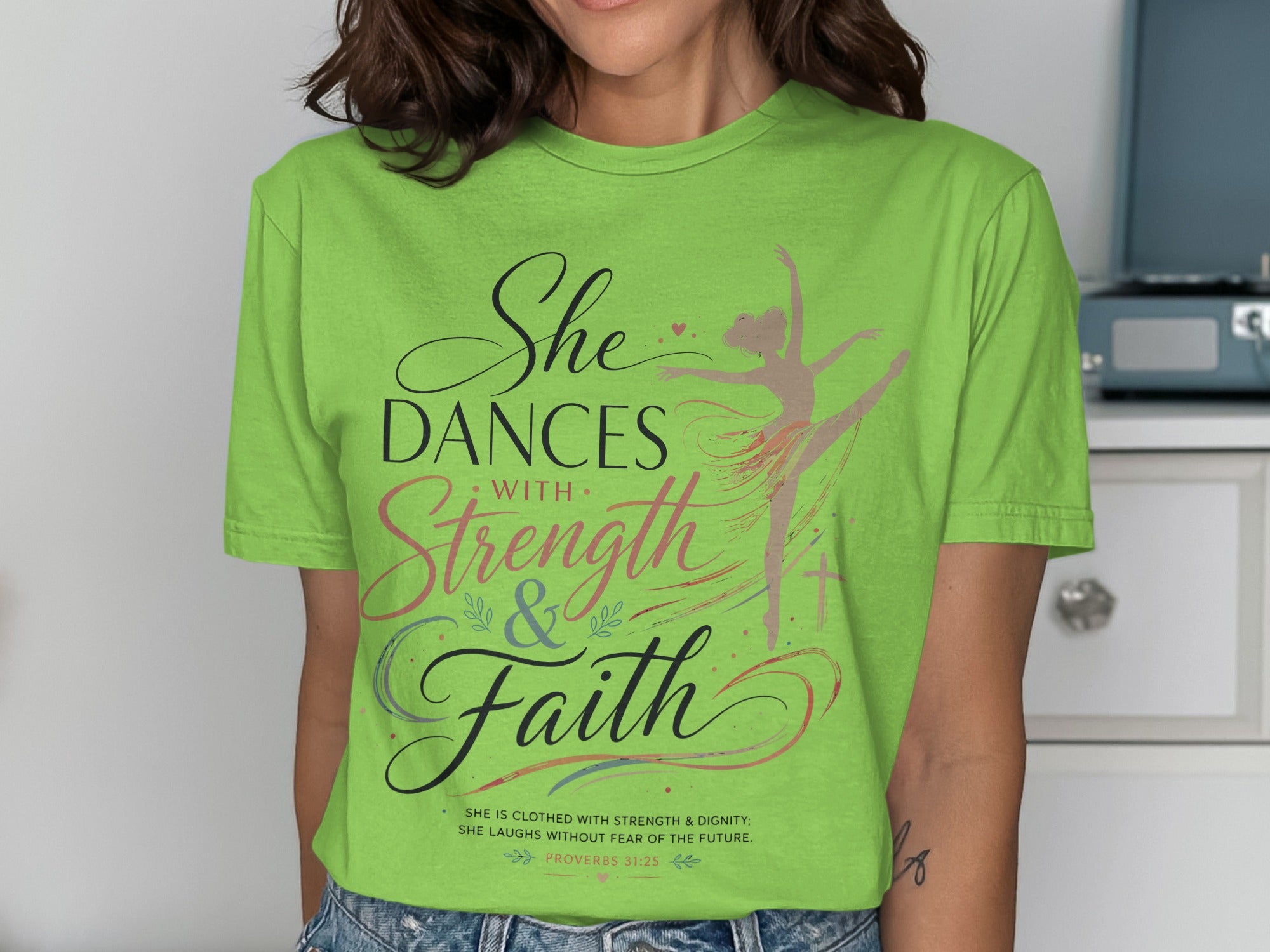 Green t-shirt with "She Dances with Strength & Faith" and Proverbs 31:25.