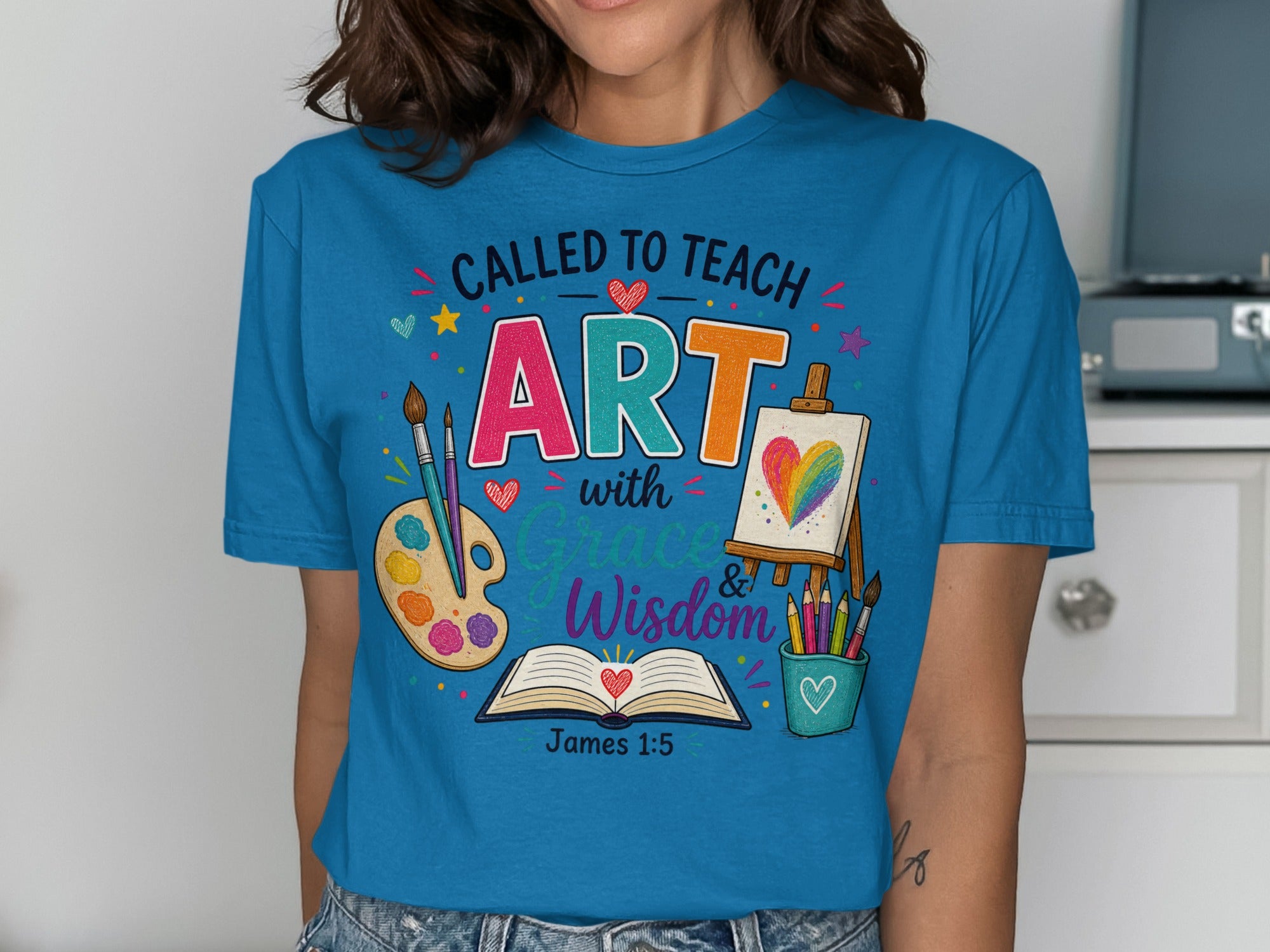 T-shirt with "Called to Teach ART with Grace & Wisdom" and art supplies.
