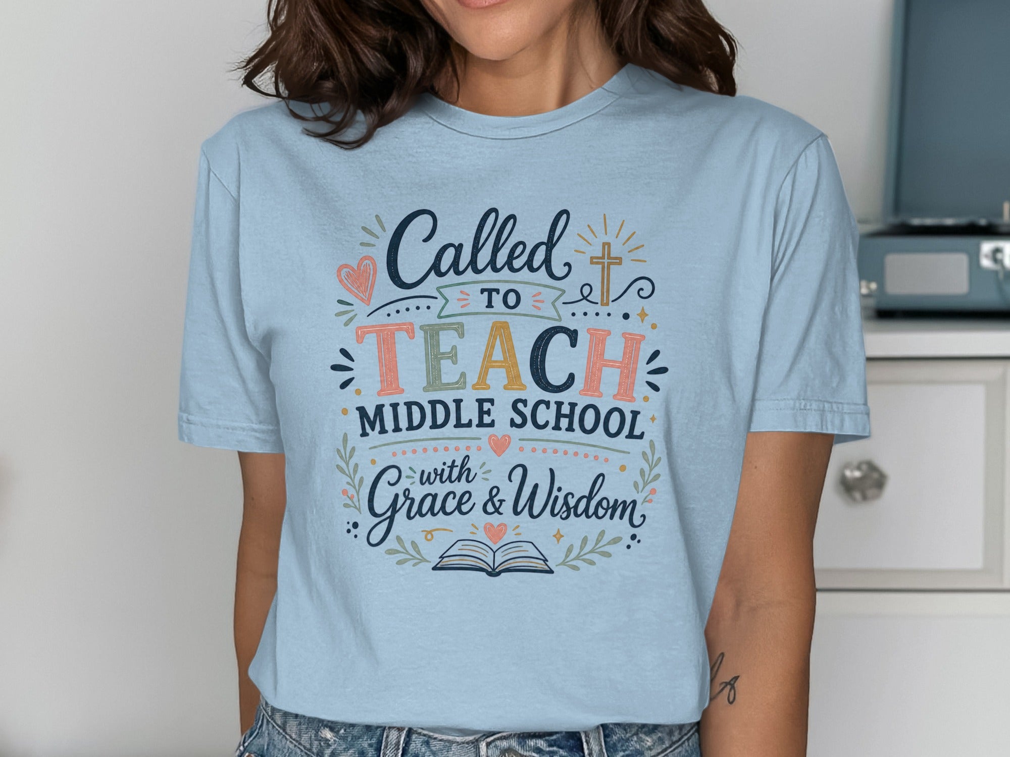 Light blue t-shirt with "Called to TEACH Middle School with Grace & Wisdom" text and decorations.