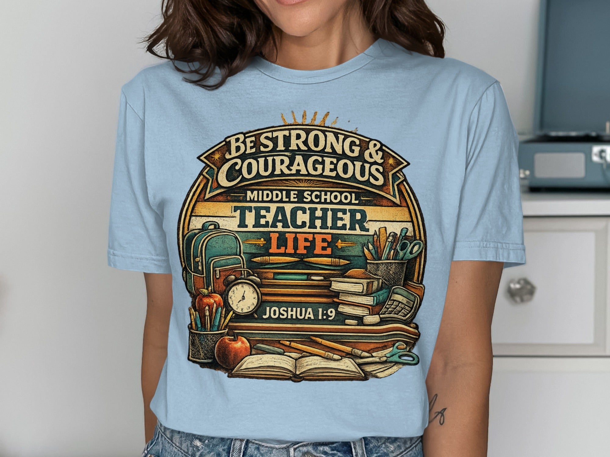 T-shirt with "Be Strong & Courageous Middle School Teacher Life" text and school supplies.
