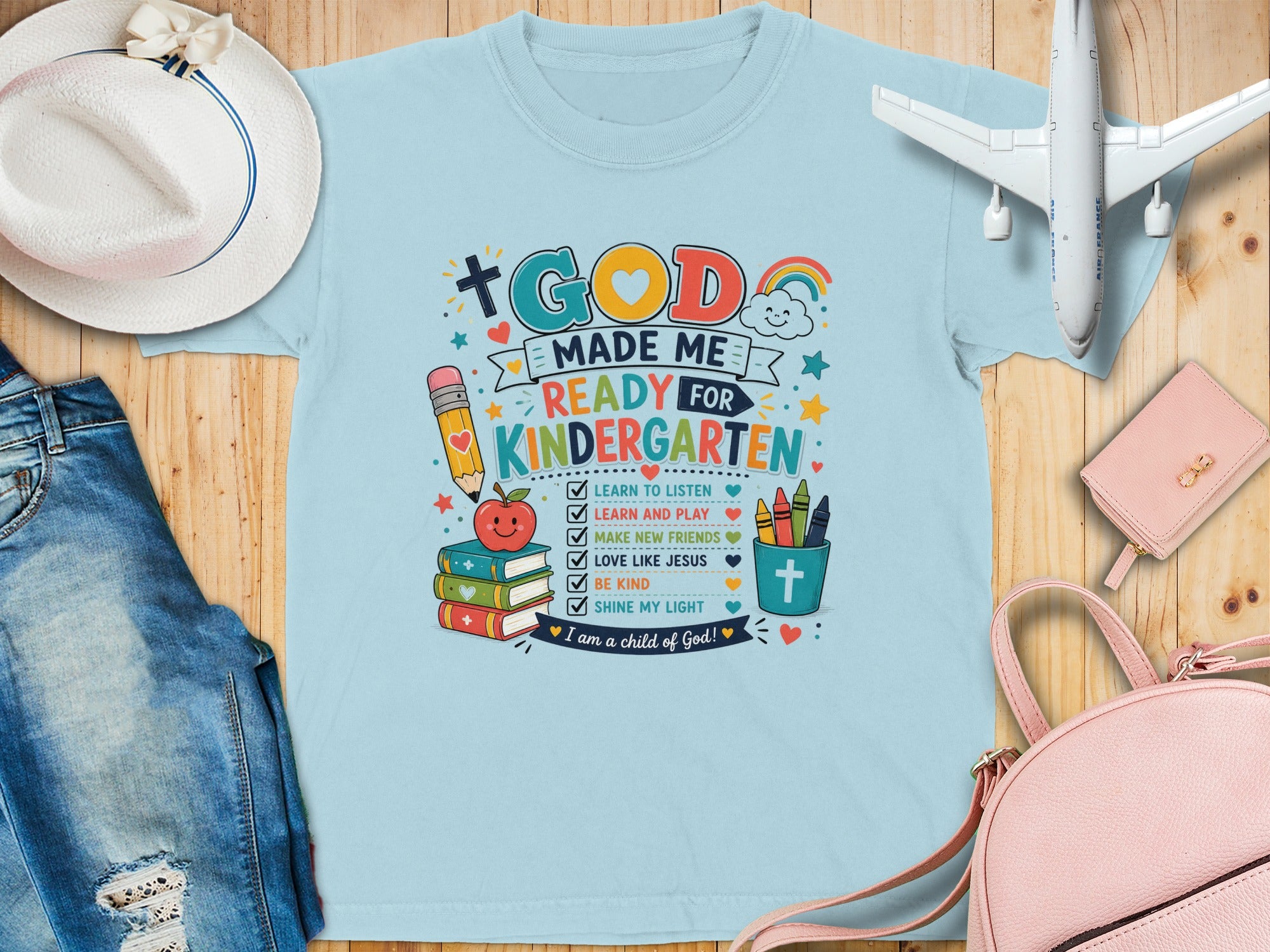 Light blue t-shirt for kindergarten with colorful God-themed graphics and text.