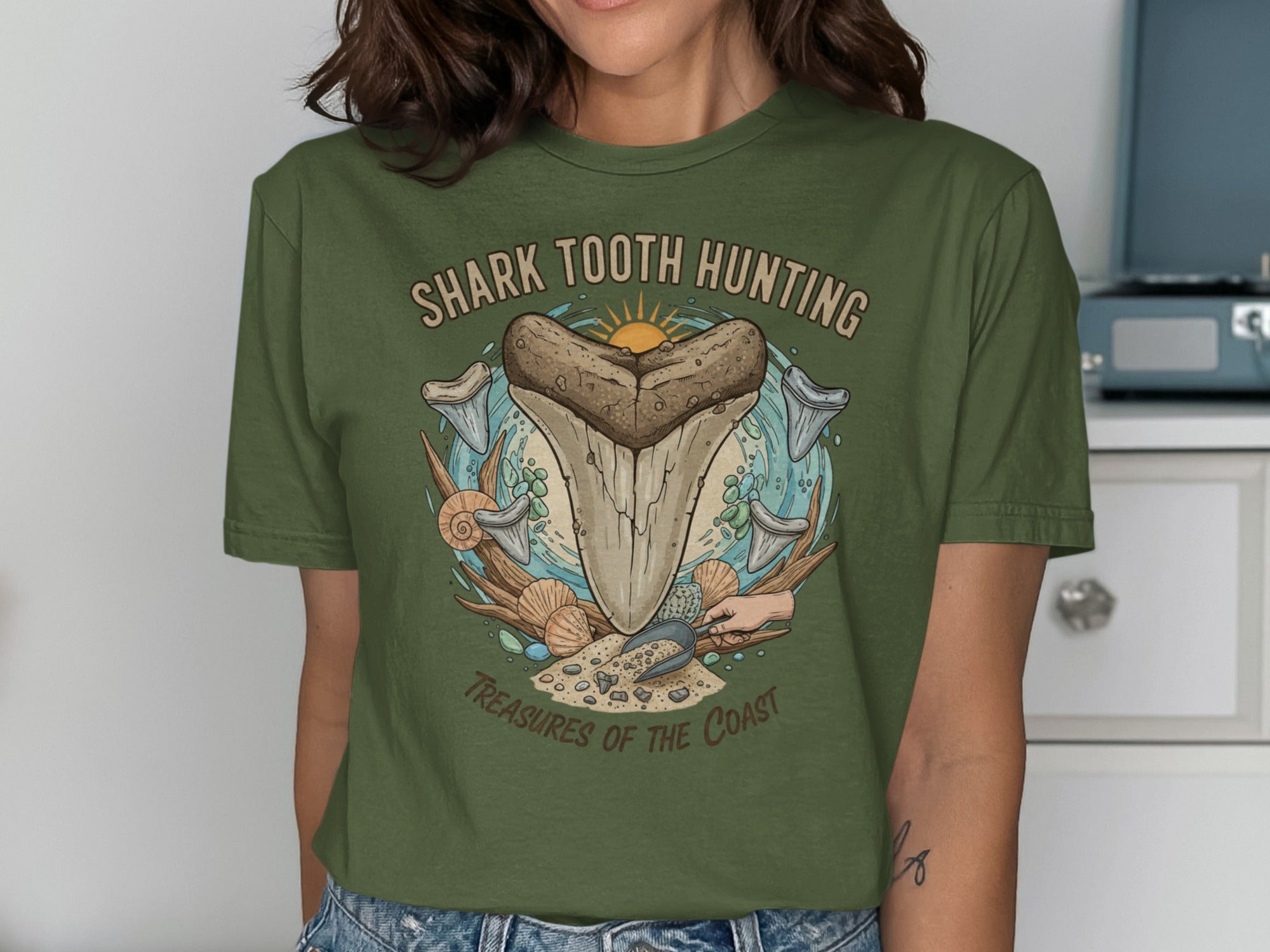 Green t-shirt with "Shark Tooth Hunting Treasures of the Coast" graphic.