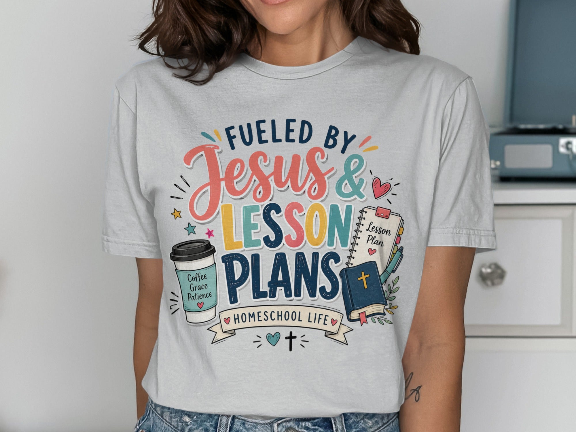 T-shirt with "Fueled by Jesus & Lesson Plans Homeschool Life" text and graphics.