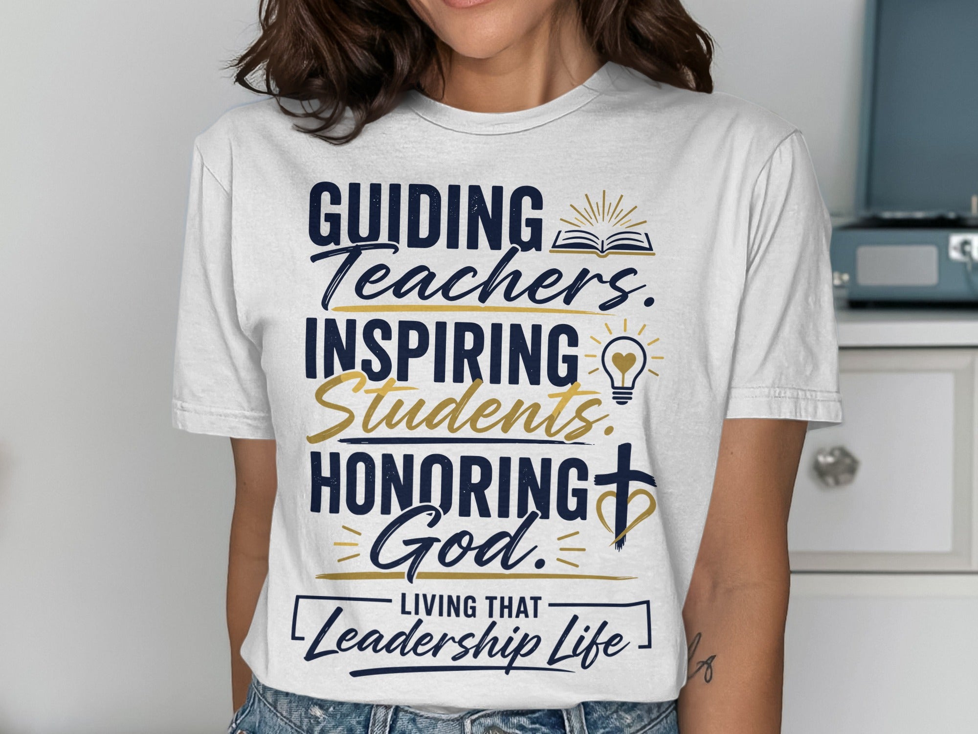 White t-shirt with "Guiding Teachers. Inspiring Students. Honoring God. Living That Leadership Life" text.