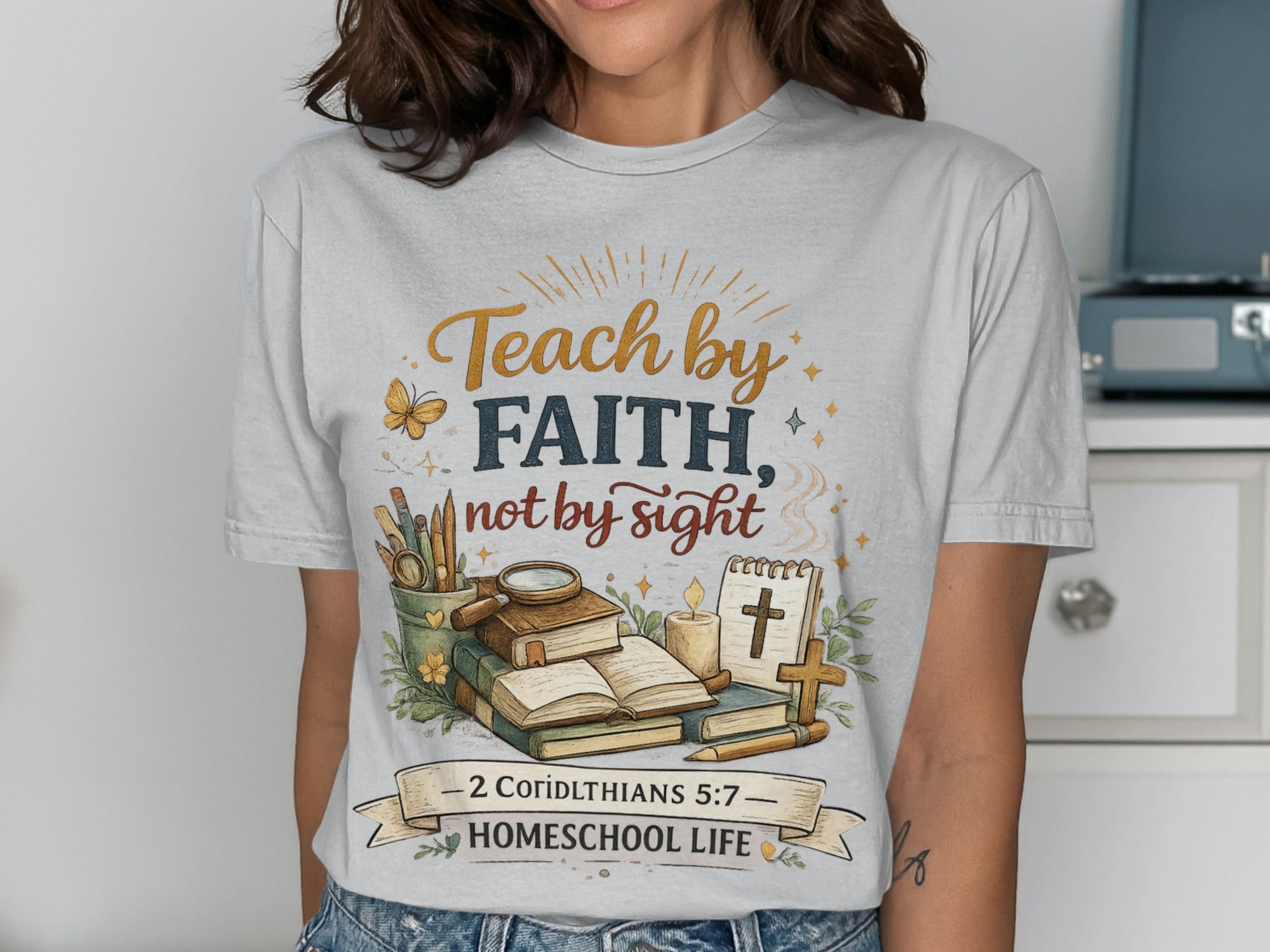 Teach by faith, not by sight Homeschool Life t-shirt with books, cross, and butterfly.
