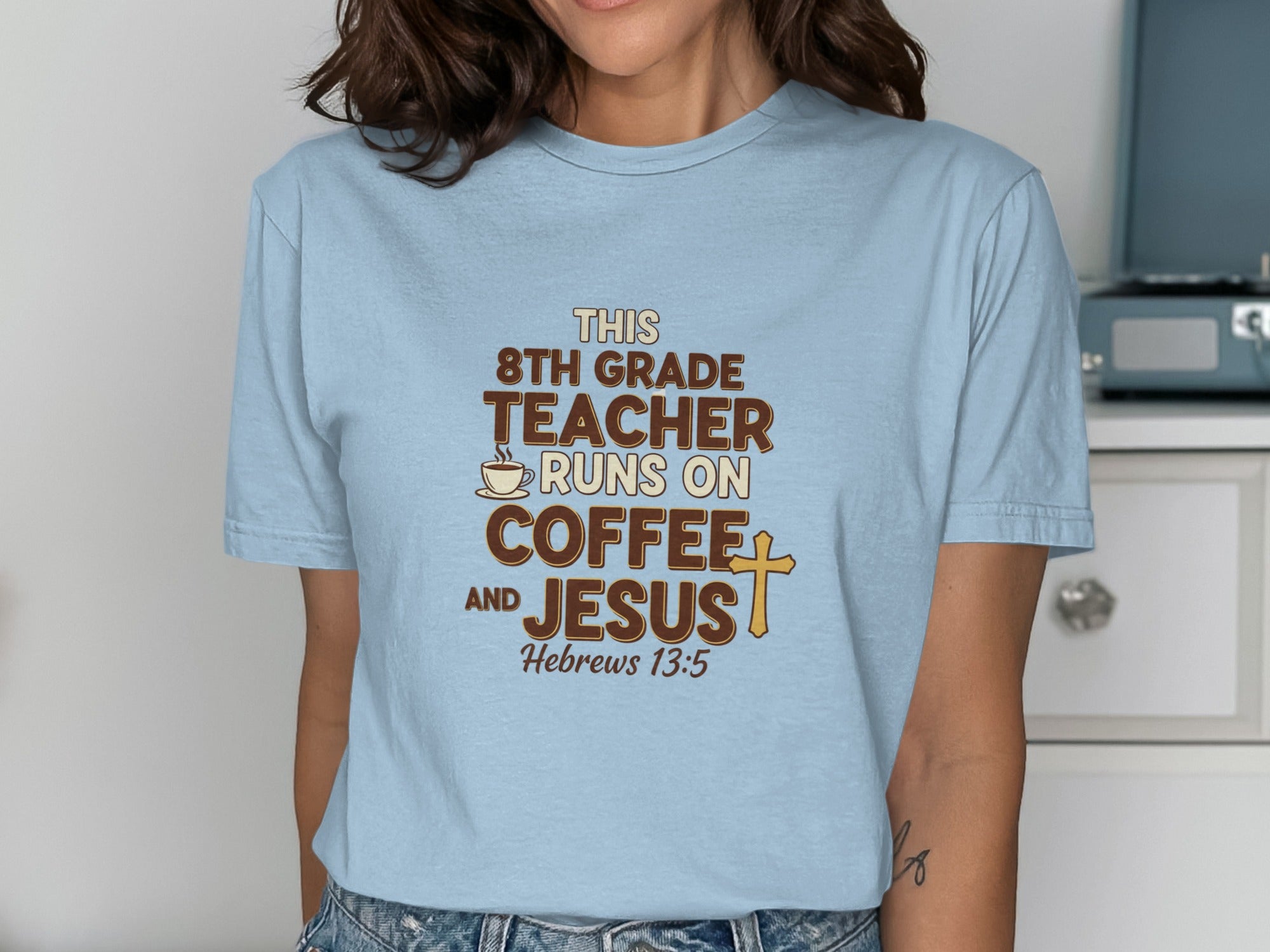 Light blue t-shirt with text: "8th grade teacher runs on coffee and Jesus."