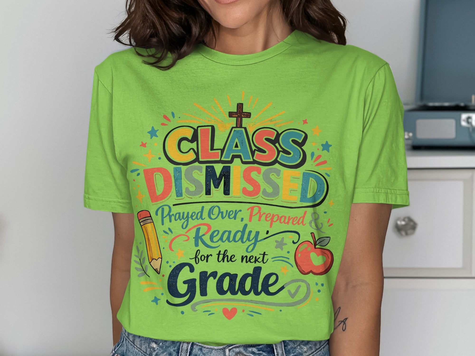 Green t-shirt with "Class Dismissed" design featuring apple, pencil, and cross.