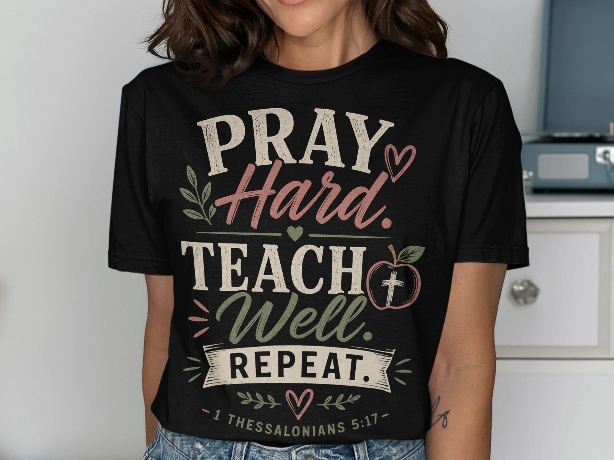 Black t-shirt with "PRAY. Hard. TEACH. Well. REPEAT." and bible verse.